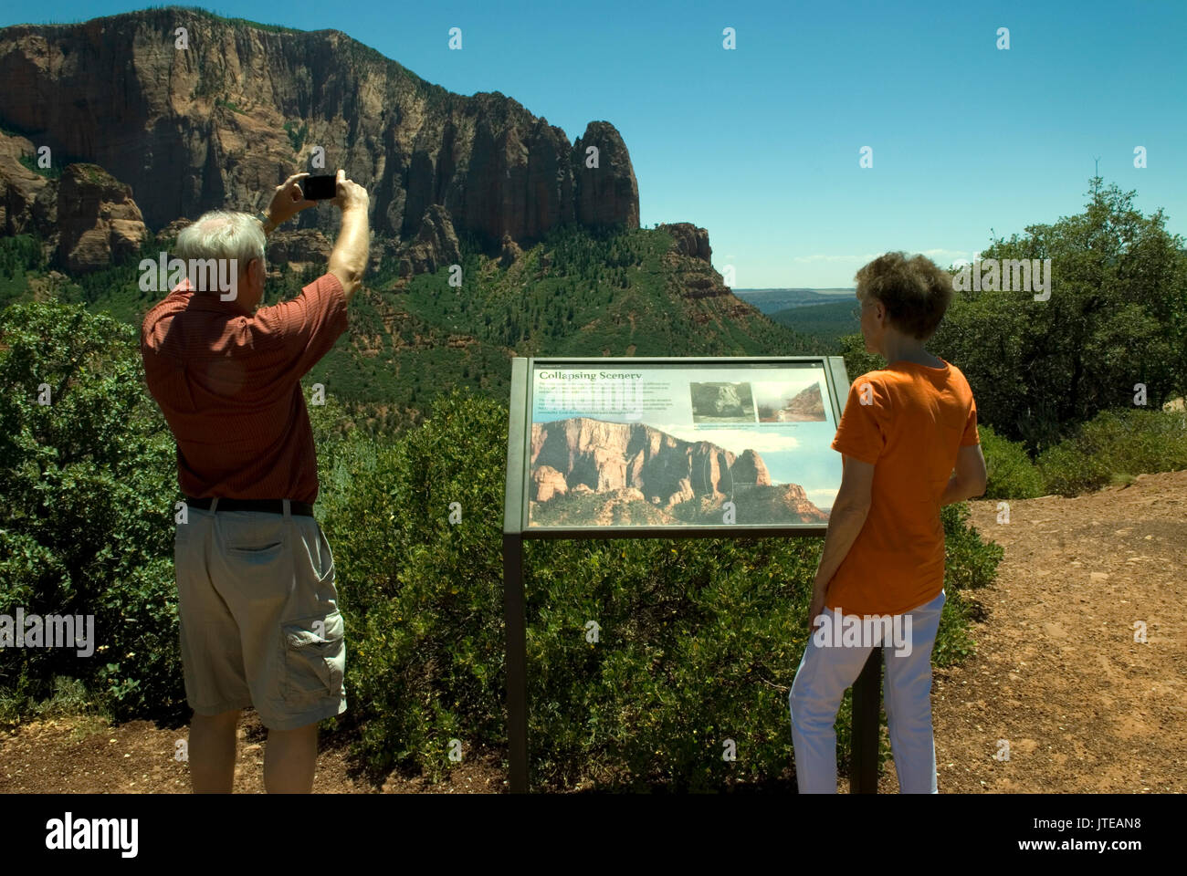 Couple de personnes âgées de race blanche (60 à 70 ans) à Kolob Canyons au parc national de Zion Springdale, Utah, États-Unis. Homme caucasien prenant des photos tandis que la femme lit des informations. Banque D'Images