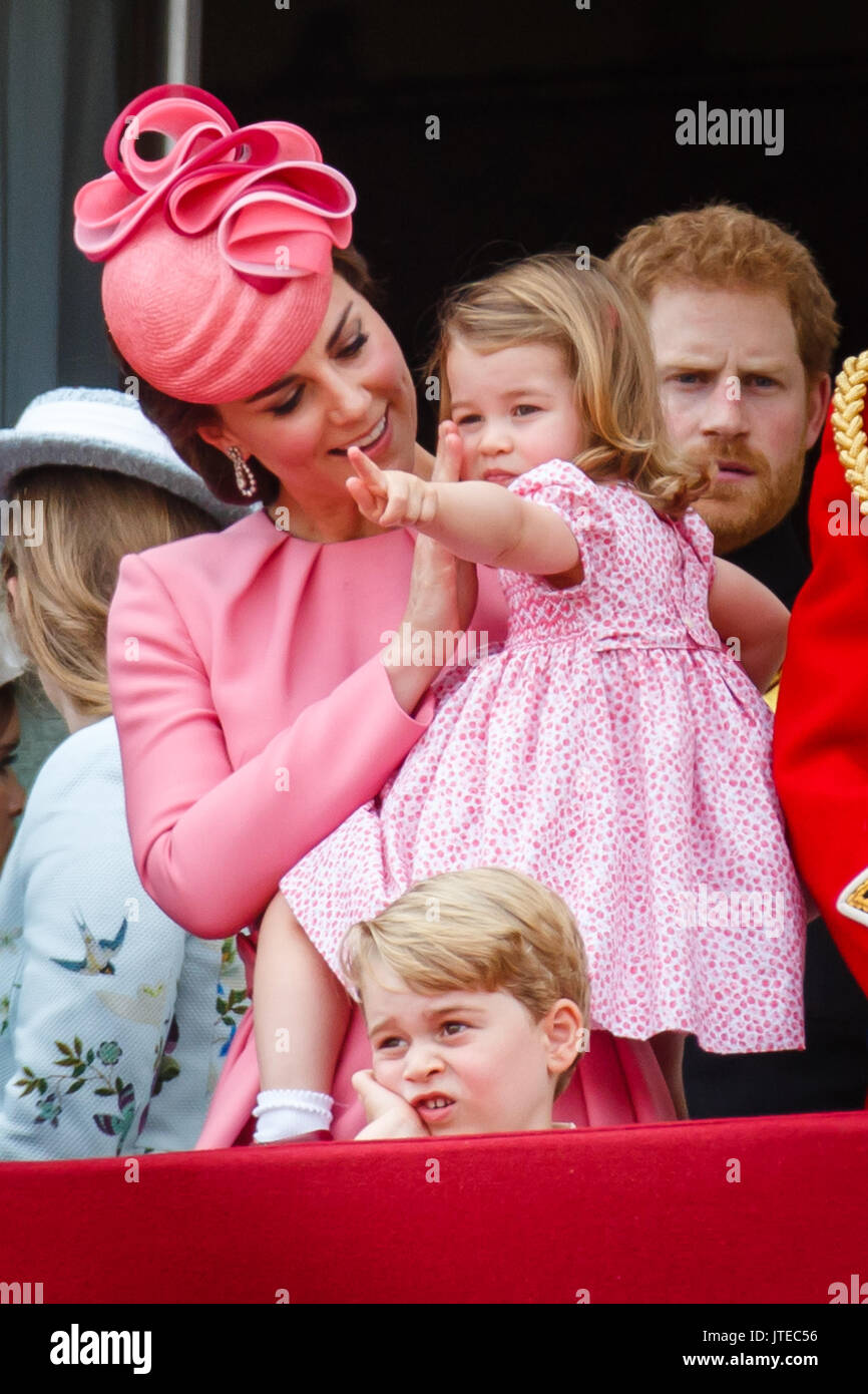 La duchesse de Cambridge transportant la Princesse Charlotte, coups affectueusement sa joue. Prince George a l'air assez Banque D'Images