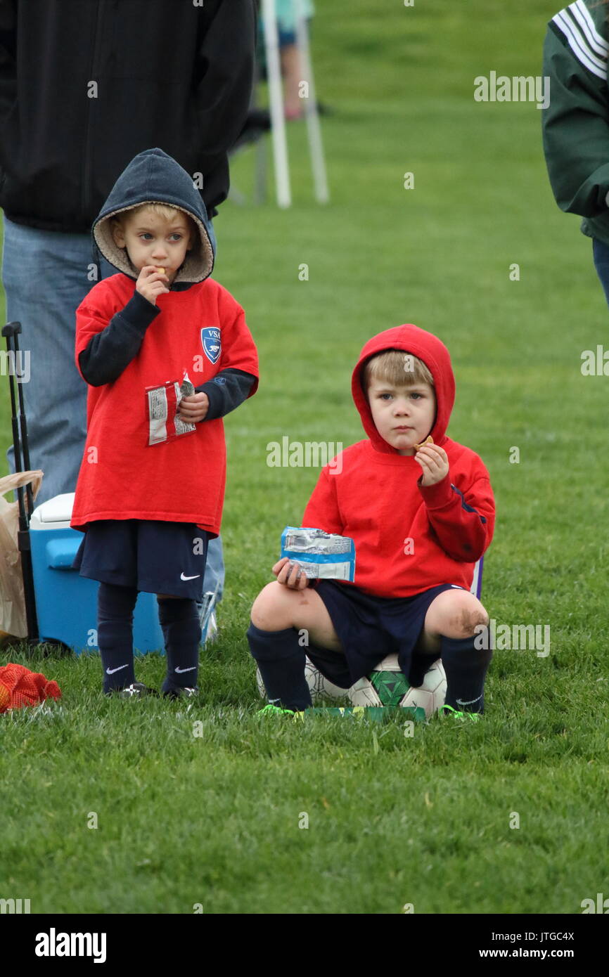 Les garçons en prenant une pause gourmande au cours d'un match de foot Banque D'Images