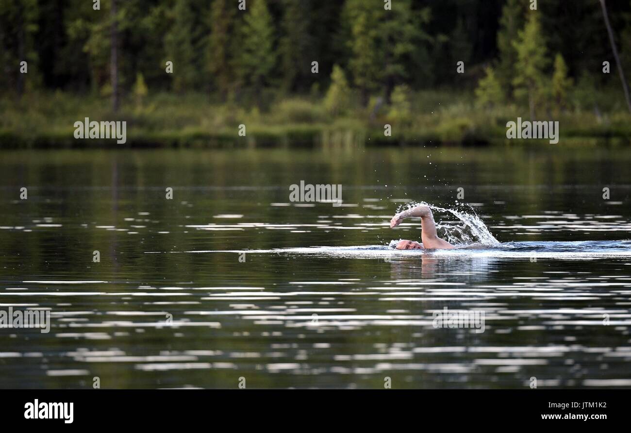 Le président russe Vladimir Poutine nage dans l'eau glacée sur un lac éloigné pendant une aventure dans le désert de Sibérie près de la frontière mongole au 3 août 2017 dans la République de Tyva, la Russie. Banque D'Images