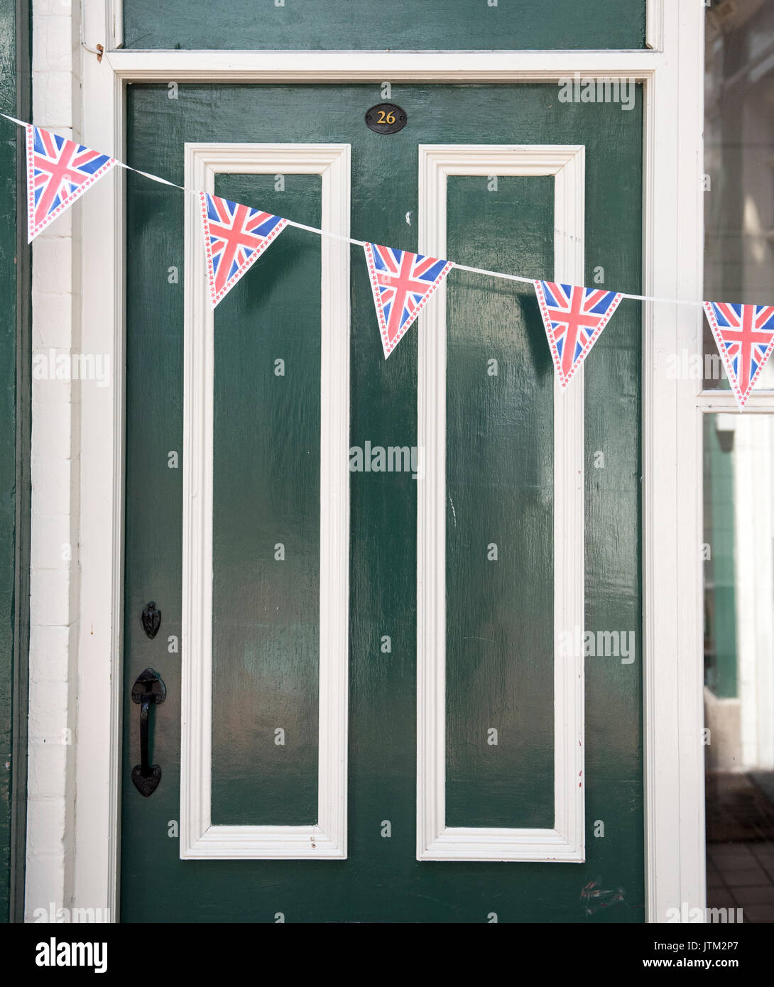 Porte d'entrée verte décorée d'une banderole Union Jack pour une célébration britannique ou un événement national Banque D'Images