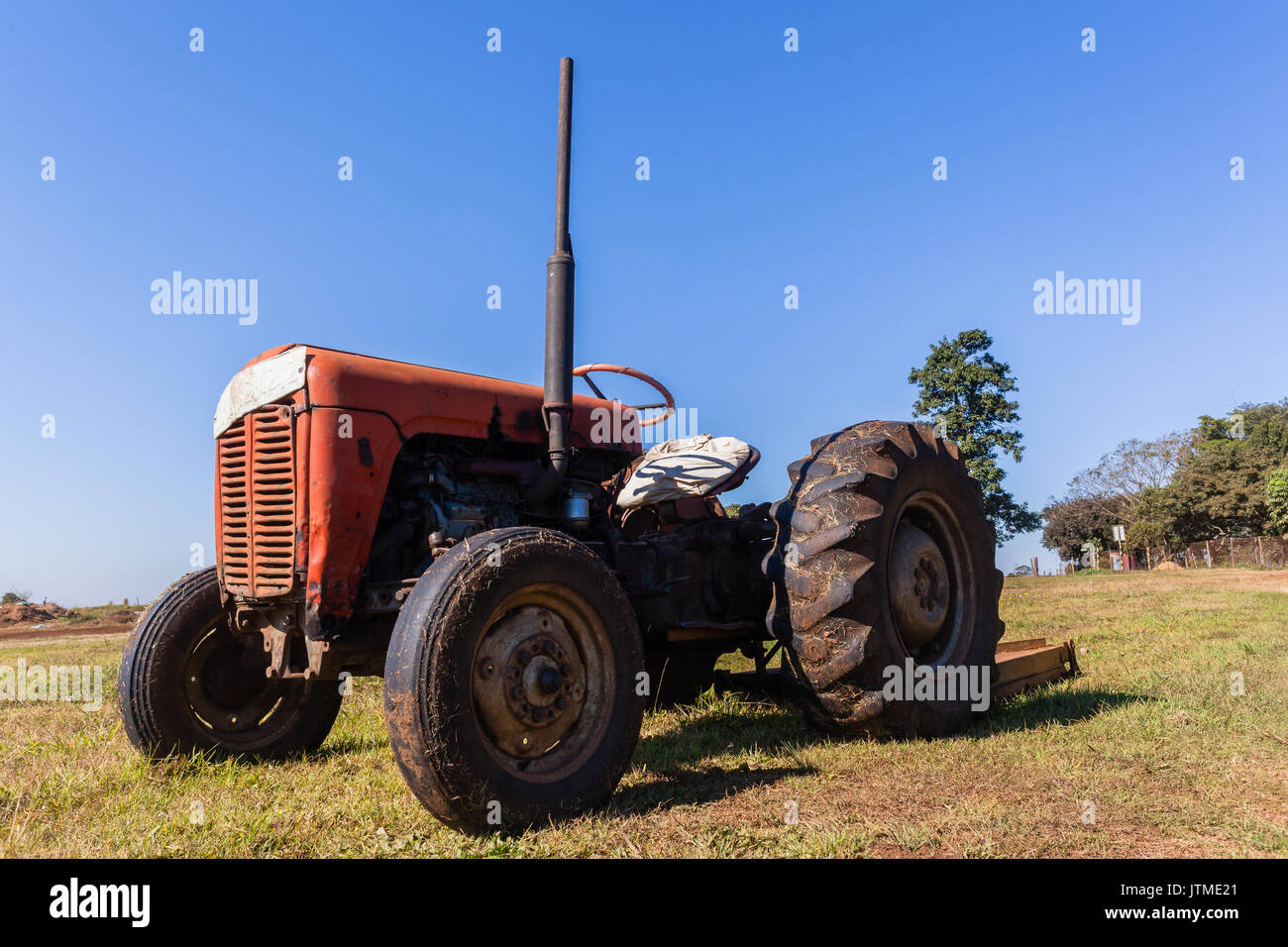 Old vintage le tracteur dans le champ, toujours avec le coupe-herbe ci-joint  Photo Stock - Alamy