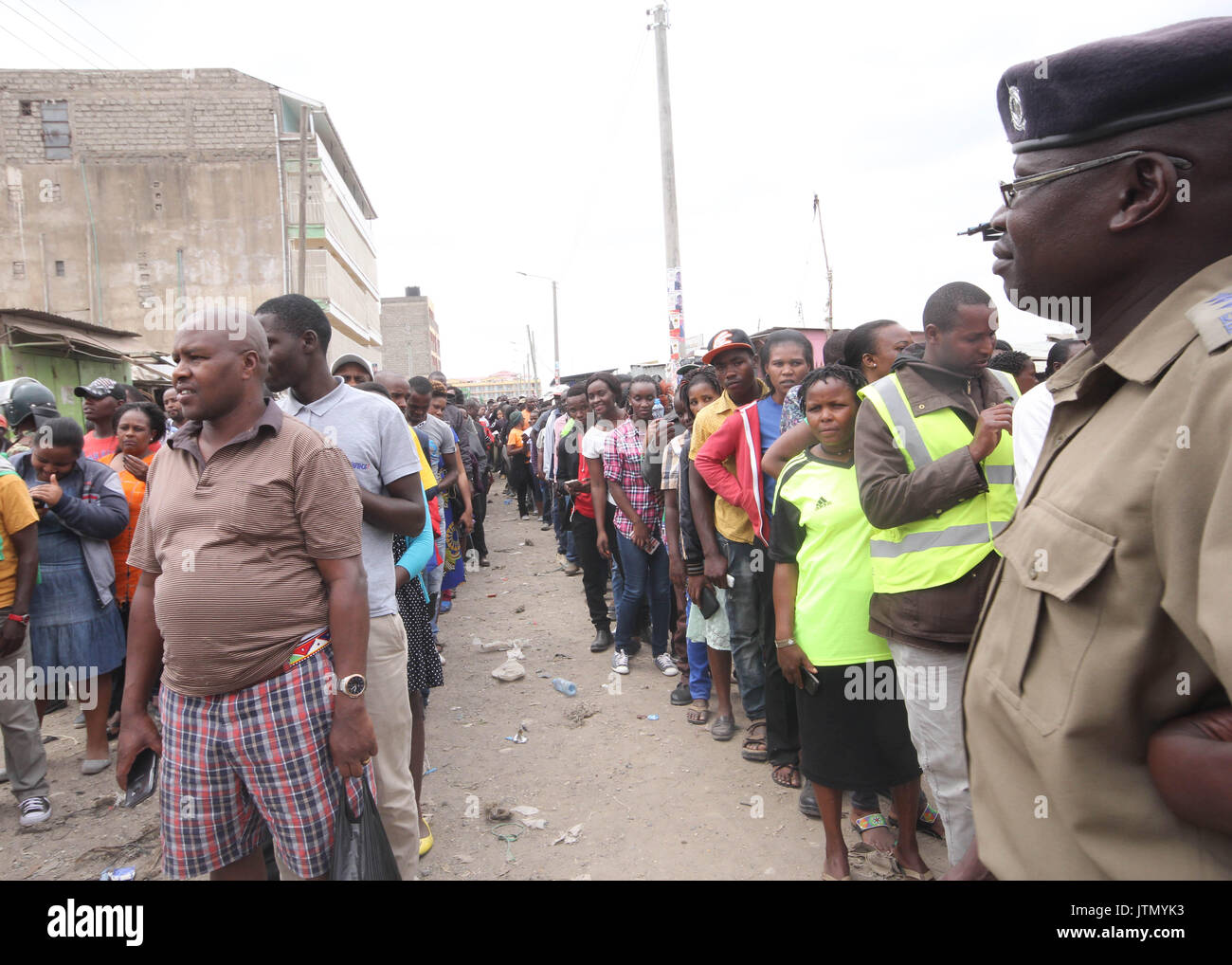 Nairobi, Kenya. Le 08 août, 2017. Mans l'agent de sécurité dans la ligne des gens de voter à un bureau de scrutin à St Monica dans le comté de Kajiado Kitengela, le 8 août 2017 à Nairobi, au Kenya. Les Kenyans rendre aux urnes pour une élection très serrée entre le président sortant, Uhuru Kenyatta et son rival Raila Odinga. Crédit : Tom Maruko/Pacific Press/Alamy Live News Banque D'Images
