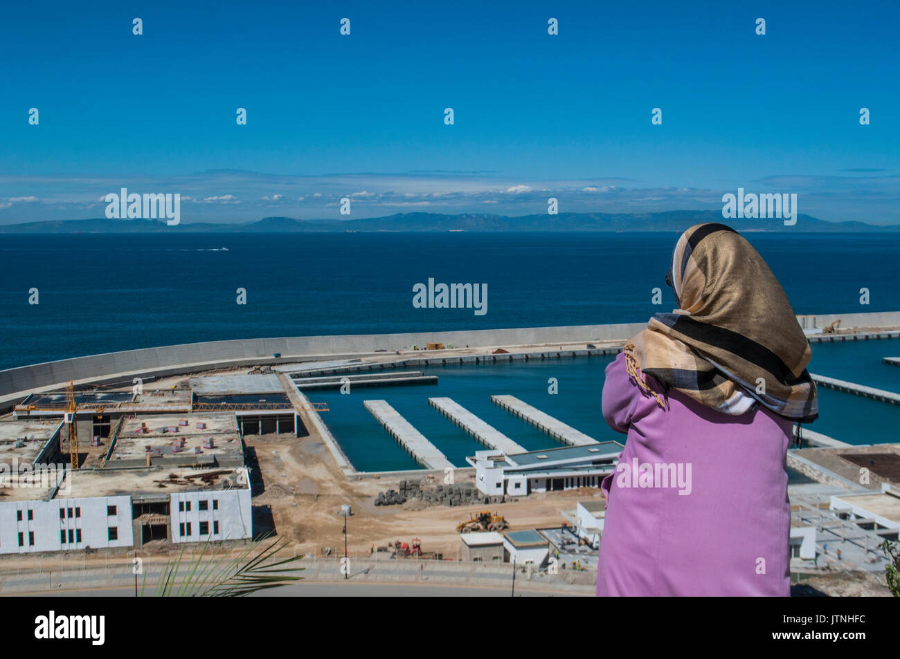 Afrique du Nord : une femme musulmane en face du port de Tanger à la recherche du détroit de Gibraltar qui sépare le Maroc de l'Espagne Banque D'Images