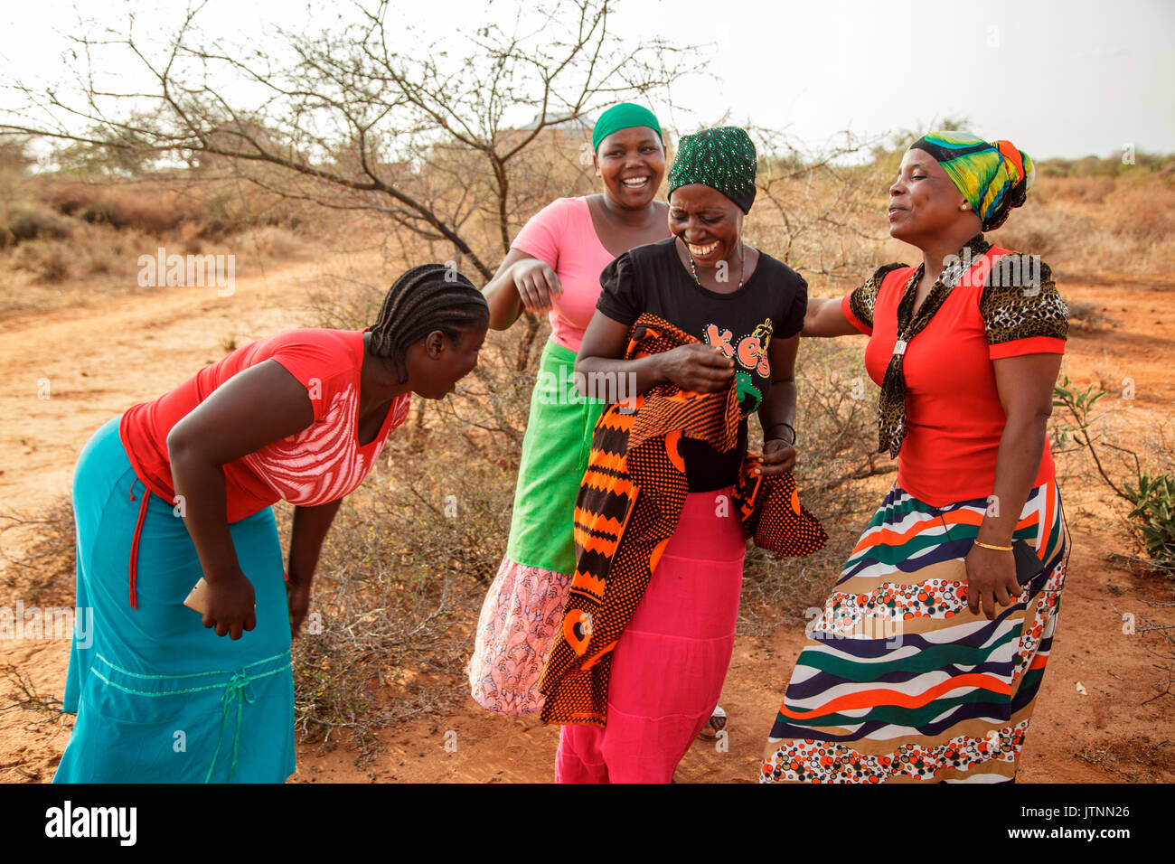 Mforo la Tanzanie, un village près de Moshi, Tanzanie. Sœur solaire visite d'entrepreneurs et de s'amuser après leur Sœur solaire réunion d'affaires à maison Mzirayâs Fatma. Fatma Mziray, vêtue d'un haut rouge et un foulard à motifs, Mwunaidi Msuya - Sœur solaire Entrepreneur, vêtu d'une écharpe verte et rose top, Grace Mbwambo - Sœur solaire Entrepreneur, vêtue d'un haut rouge et turquoise jupe, Grace Kimaro - Sœur solaire Entrepreneur dans top blanc et écharpe, et Sadia Abdallah - Sœur solaire Entrepreneur, vêtu d'une écharpe noire et un haut noir avec un dessin. Banque D'Images