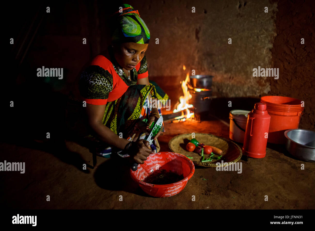 Mforo la Tanzanie, un village près de Moshi, Tanzanie. Sœur solaire entrepreneur Fatma Mziray cuire le dîner sur son fourneau propre qui utilise le bois. Fatma Mziray solaire est un entrepreneur qui vend à la fois Sœur cookstoves propre et lanternes solaires. Fatma a entendu parler du d'une Sœur solaire cookstoves adjointe au développement et a décidé d'essayer une Banque D'Images