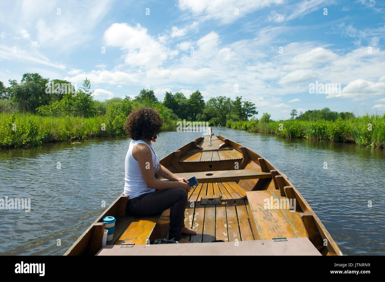Jeune femme dans un bateau en bois, profiter de la nature à proximité du lac Bovenwijde dans Giethoorn, Pays-Bas Banque D'Images