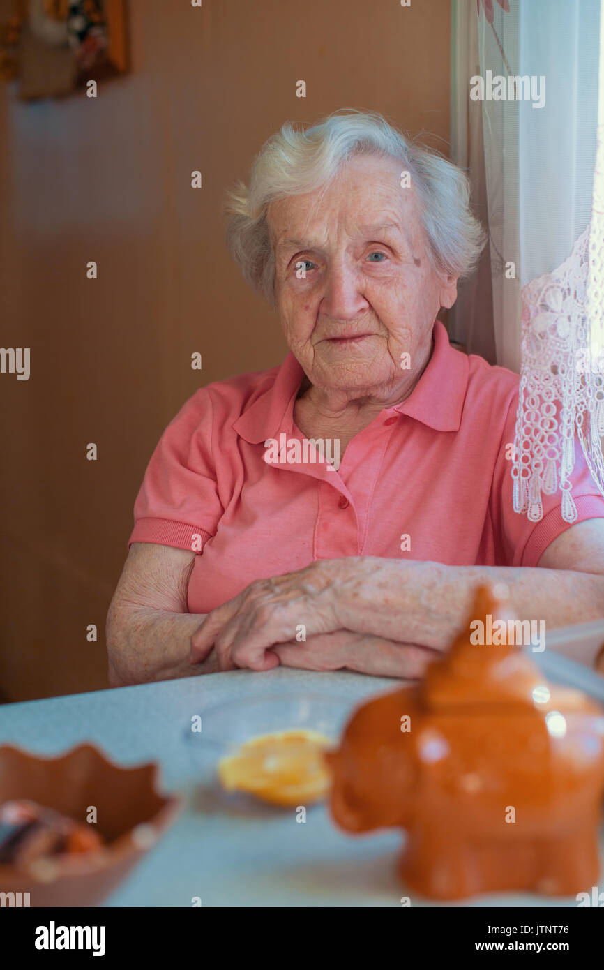 Une femme âgée dans sa maison, au portrait cuisine. Banque D'Images