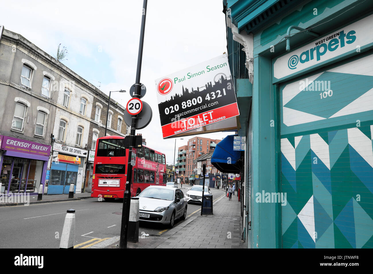 Bus à impériale rouge passant magasins sur la Route verte de l'Ouest dans la zone des Sept Sœurs Tottenham North London N15 UK KATHY DEWITT Banque D'Images