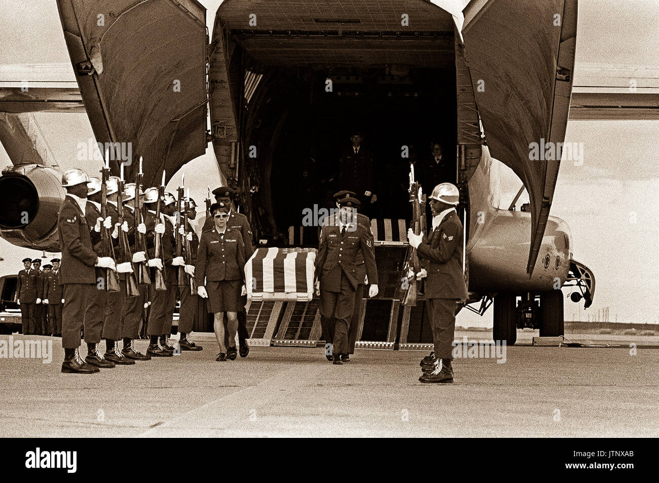 Une garde d'honneur de la Force aérienne est à l'attention tandis que la boîte de transfert d'un MIA du Nord Vietnam est retiré d'un avion C-141 Starlifter. Banque D'Images