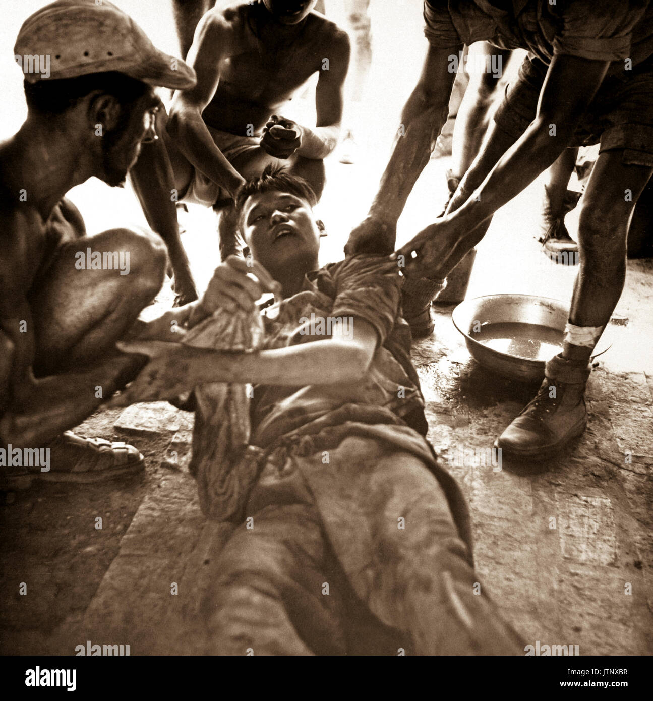 Un prisonnier blessé Viet Minh est donné par Franco de premiers soins médicaux vietnamiens après feu chaud lutte près de Hung Yen, au sud de Hanoi. Ca. 1954 (USIA) DATE EXACTE INCONNUE SHOT #  FICHIER NARA : 306-PS-54-11793 LIVRE Guerres et conflits #  : 384 Banque D'Images