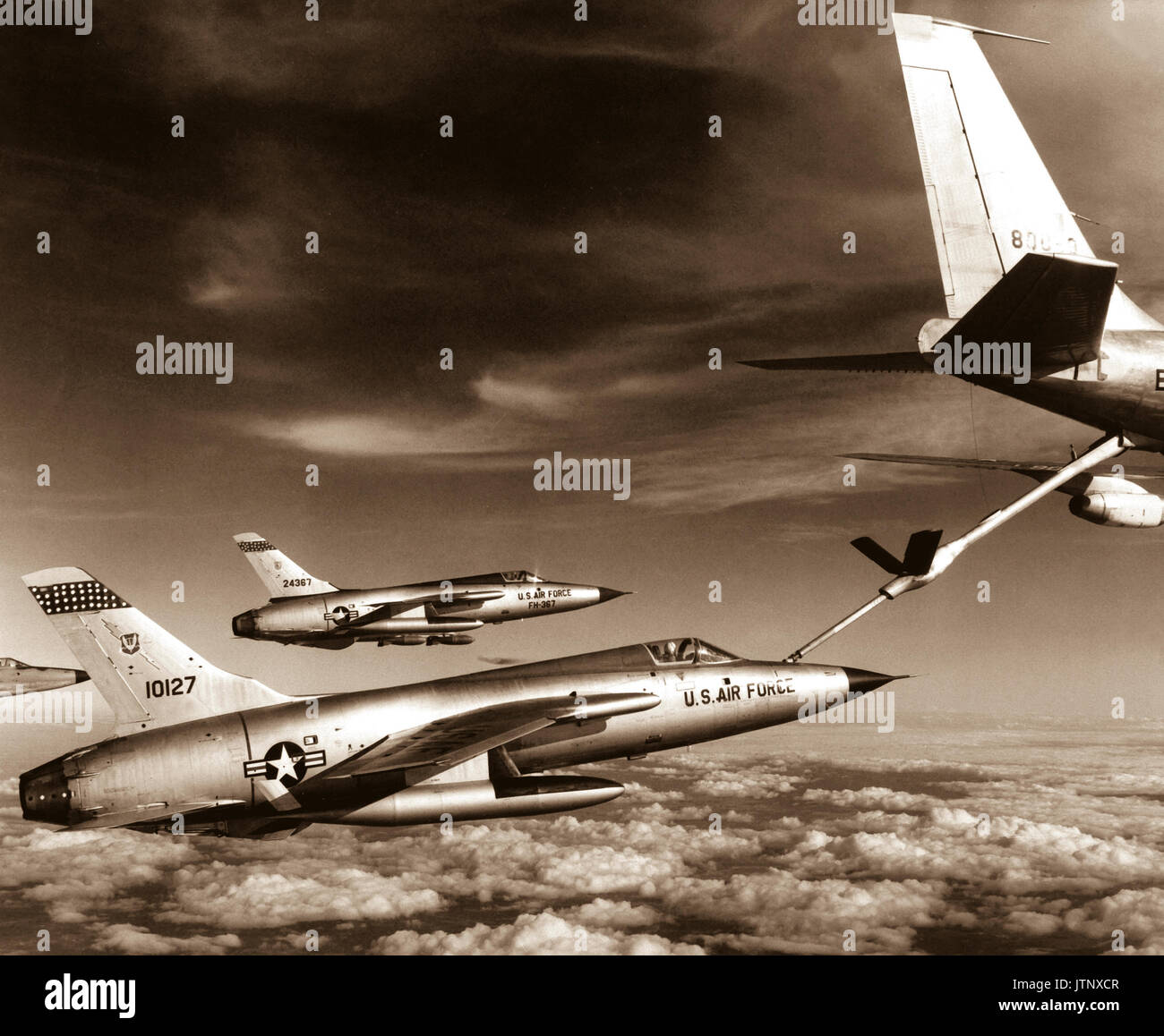 Trois Air Force F-105 Thunderchief enroute pilotes de bombarder la cible militaire au Vietnam le tirer vers le haut pour un vol de Air Force "station d'essence." L'avion de ravitaillement de l'Armée de l'air est un KC-135 Stratotanker. Janvier 1966. Air Force. (USIA) DATE EXACTE INCONNUE SHOT #  FICHIER NARA : 306-MVP-14-28 #  LIVRE Guerres et conflits : 416 Banque D'Images