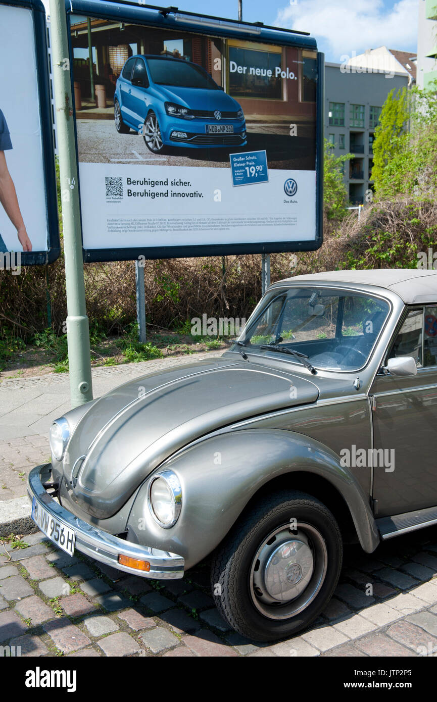 Une coccinelle Volkswagen vintage garée à côté d'une publicité VW Polo moderne, Berlin, Allemagne Banque D'Images