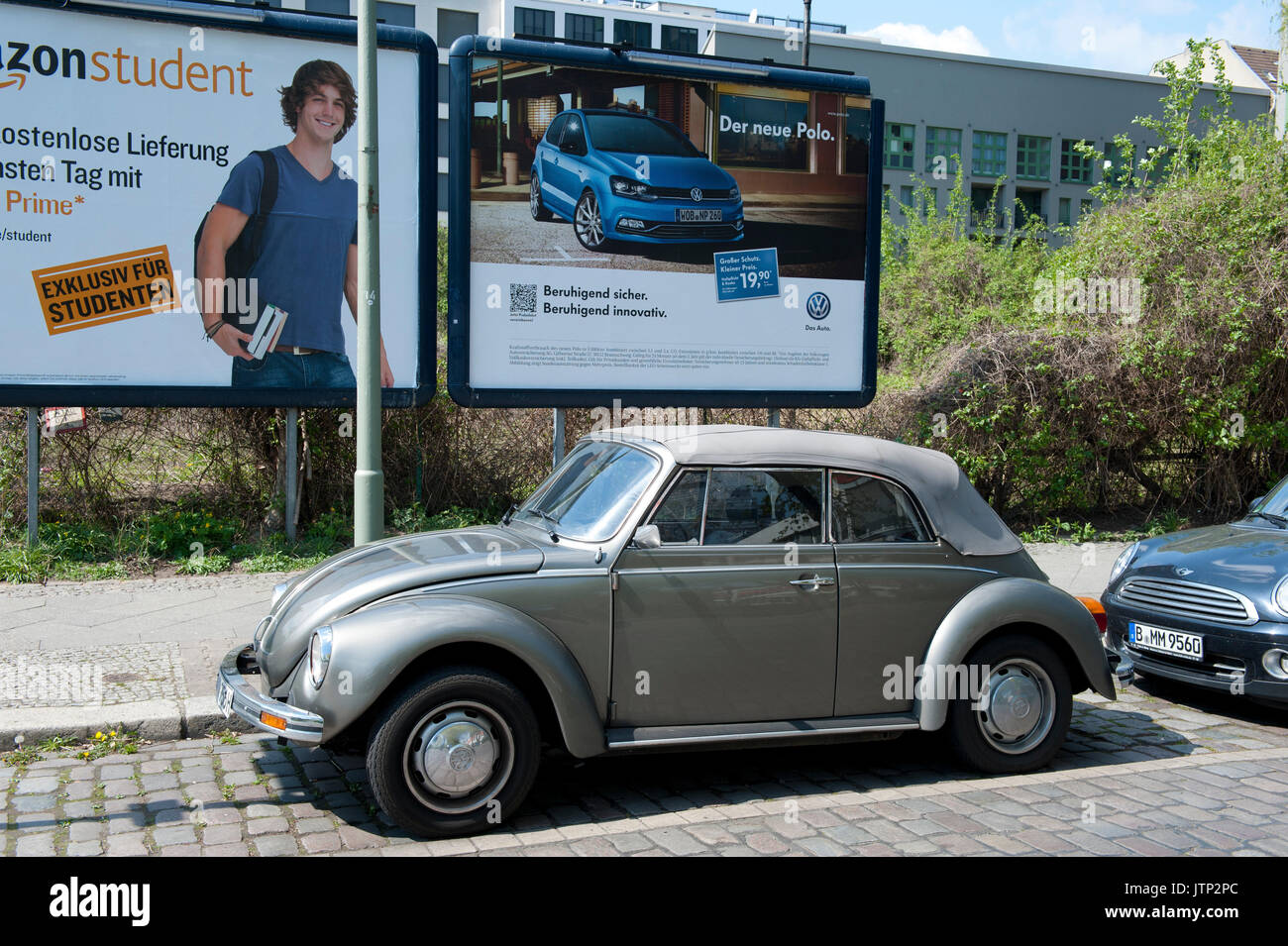 Une coccinelle Volkswagen vintage garée à côté d'une publicité VW Polo moderne, Berlin, Allemagne Banque D'Images