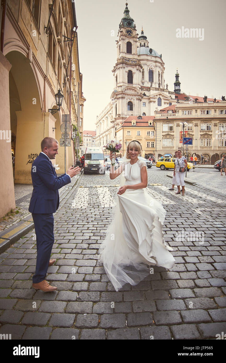 Les jeunes à pied autour de Prague. Ils voient les sites touristiques de la ville et sourire à des passants. Le soleil illumine le chemin pour un jeune couple. Banque D'Images