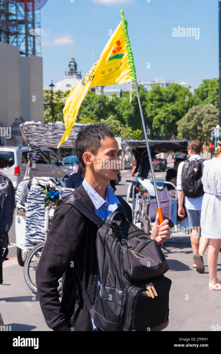 UK London Westminster Bridge guide touristique de l'est oriental drapeau jaune sac à dos les pousse-pousse trishaws arbre arbres Place du Parlement trafic voitures Banque D'Images