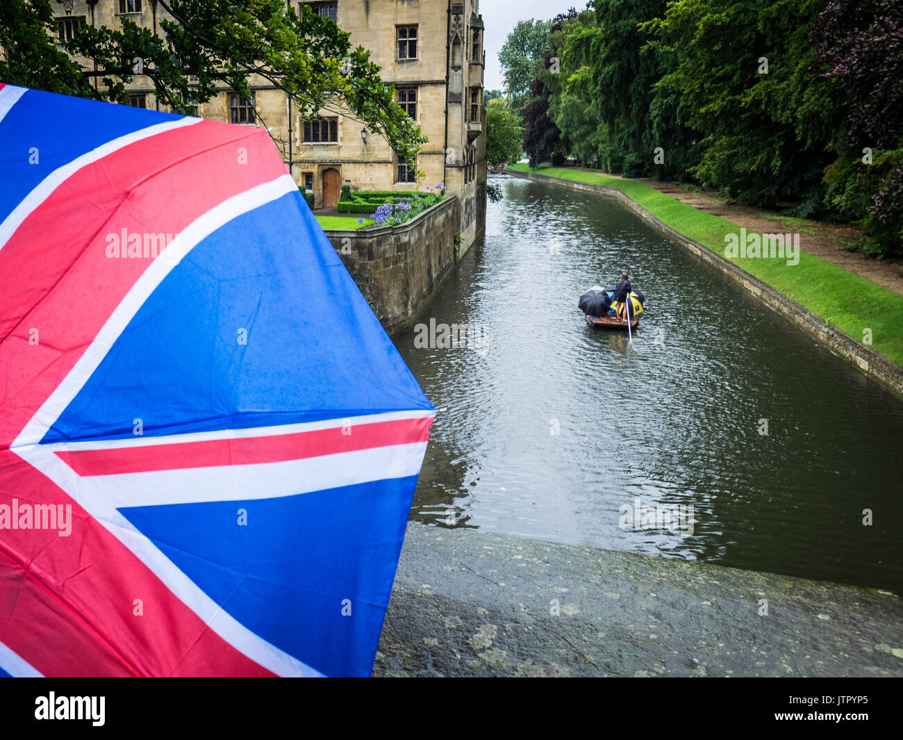 Les touristes avec un parapluie Union Jack dans de fortes pluies près de la rivière Cam à Cambridge UK Banque D'Images