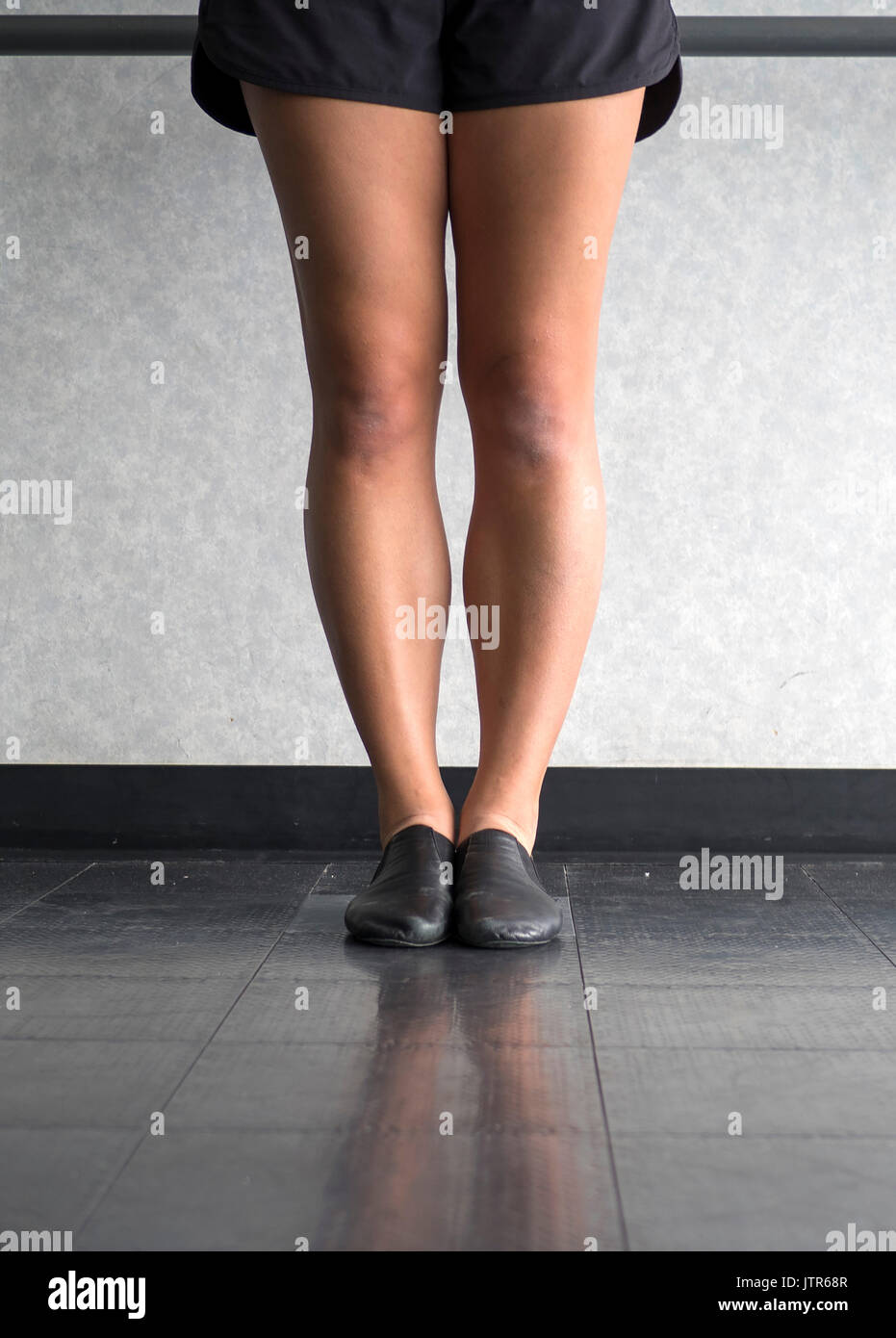Les jambes d'une danseuse de jazz en première position à la barre dans la catégorie jazz Banque D'Images