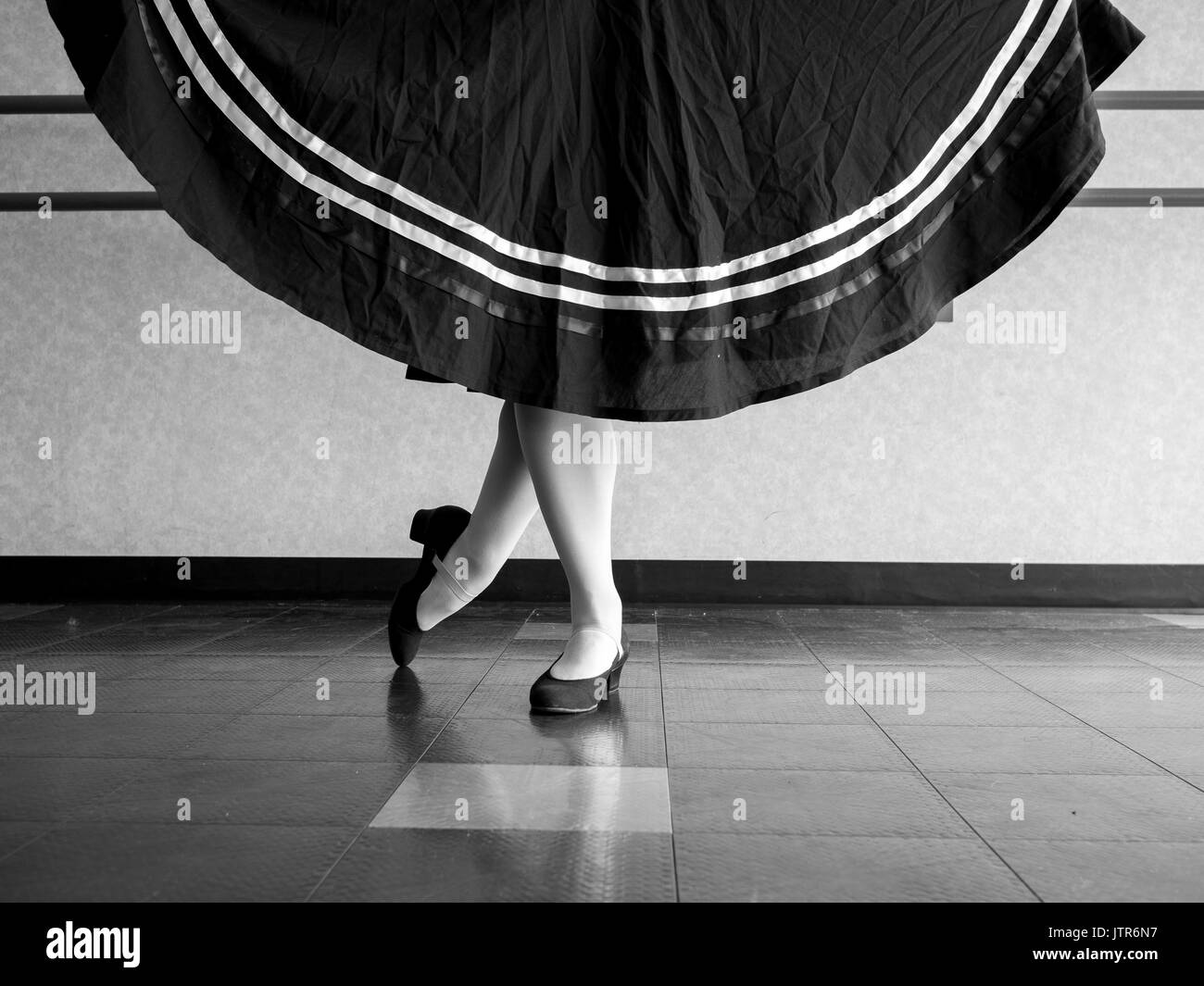 Version noir et blanc du danseur en position classique avec jupe tenue en tenue de ballet de caractère Banque D'Images