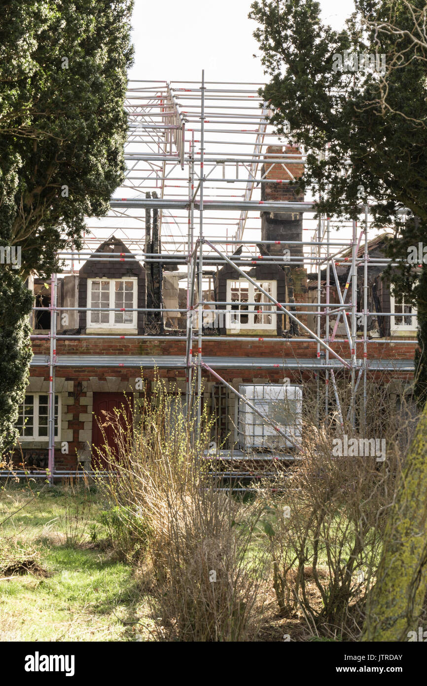 Un échafaudage recouvrant le feu des maisons endommagées, en rénovation Banque D'Images