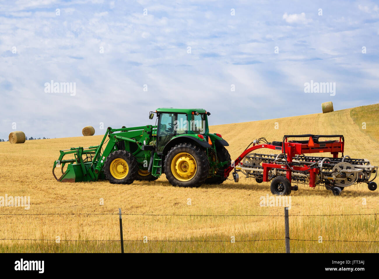 Dans le domaine du tracteur avec un râteau râteau foin.. ci-joint fond de ciel bleu. Banque D'Images