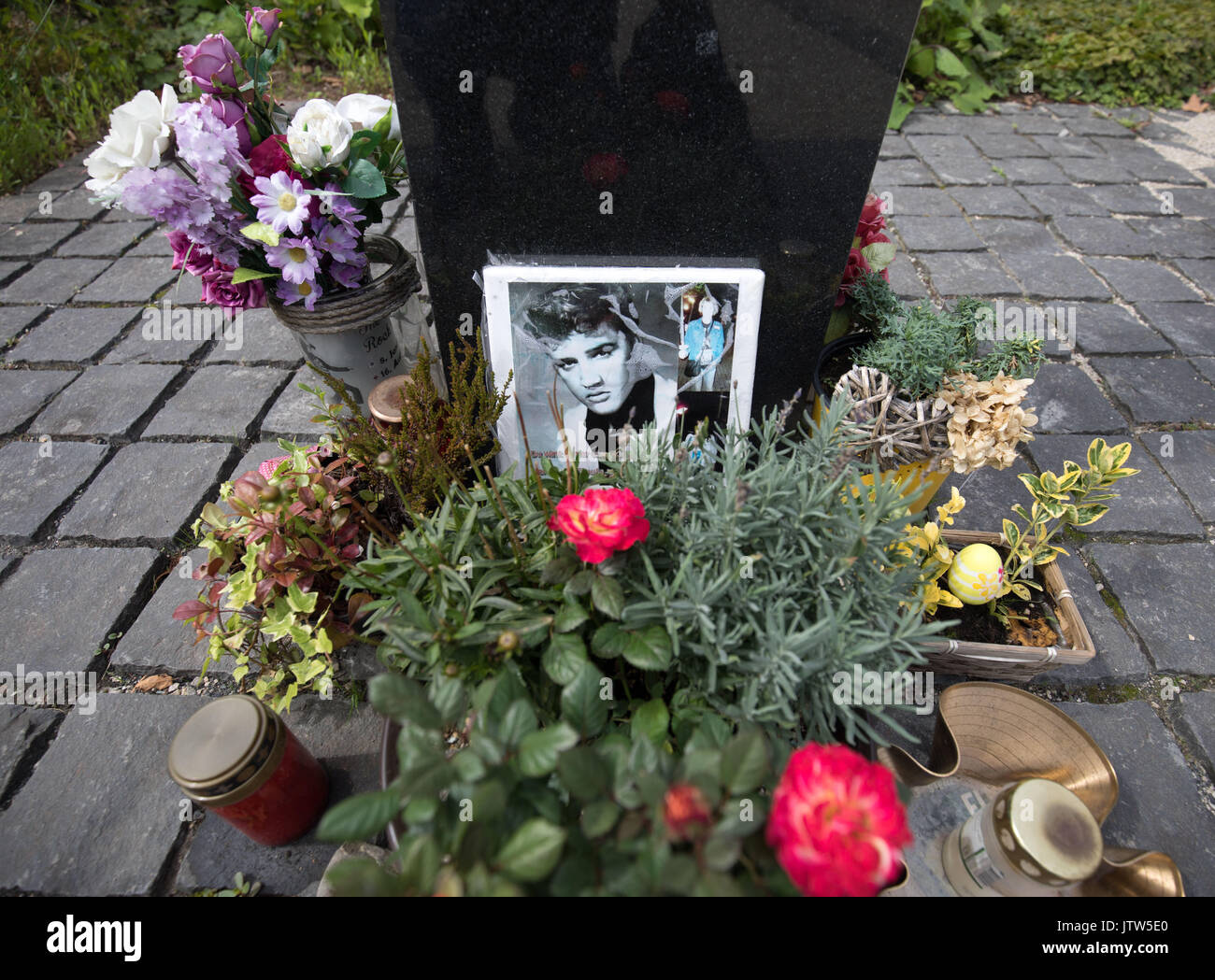 Des fleurs, des bougies et une photo peut être vu à la Elvis Presley memorial, tandis que l'Hôtel Villa Grunewald, où Elvis Presley séjourné entre octobre 1958 et février 1959, est à l'arrière-plan, à Bad Nauheim, Allemagne, 04 août 2017. Beaucoup de choses dans l'hôtel sont encore dans leur état d'origine à partir des années 1950, lorsque le roi du rock n' Roll a fait son service militaire dans l'par Friedberg. Depuis il y a peu de temps la célèbre chambre peut être une fois de plus réservé dans la complètement restauré et inauguré récemment re-construire à partir de 1888. Photo : Frank Rumpenhorst/dpa Banque D'Images