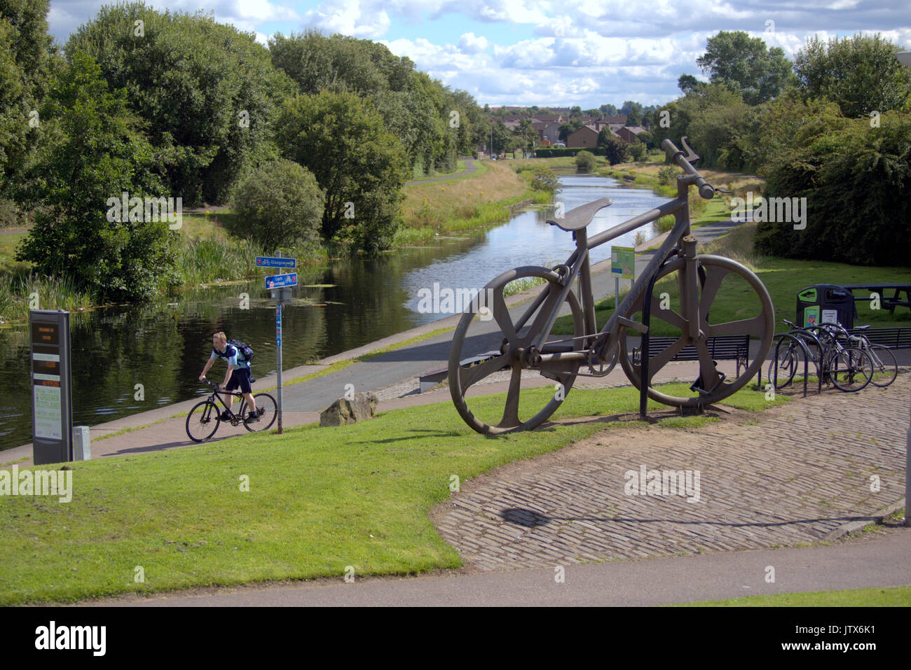 Cycliste sur NCN 7 passer le vélo Bankies sculpture à l'été de Clydebank retour du beau temps et des habitants de profiter de l'été sur le Forth and Clyde canal Banque D'Images