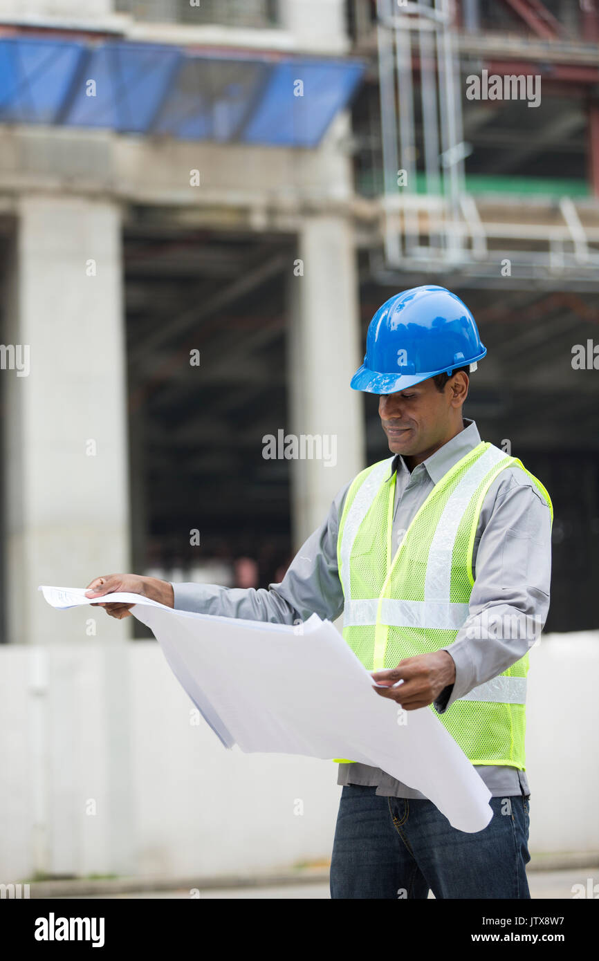 Construction manager ou un architecte indien contrôle du plan plans à l'emplacement de l'édifice. Banque D'Images