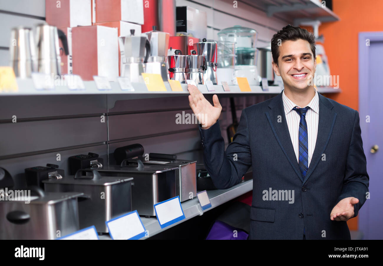 Homme joyeux consultant travaillant à petits appareils ménagers article and smiling Banque D'Images