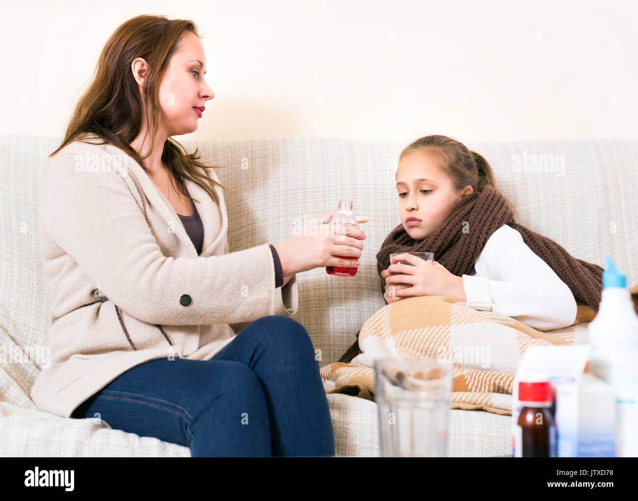 Mère fille malade d'infirmières. Elle donne à son enfant un remède contre la toux Banque D'Images