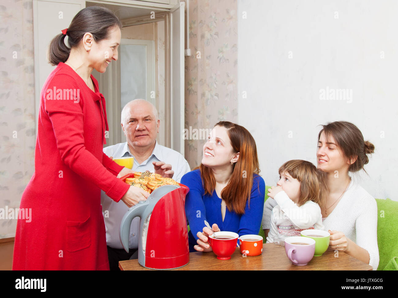 Famille multigénérationnelle communiquer sur un plateau avec des gâteaux Banque D'Images