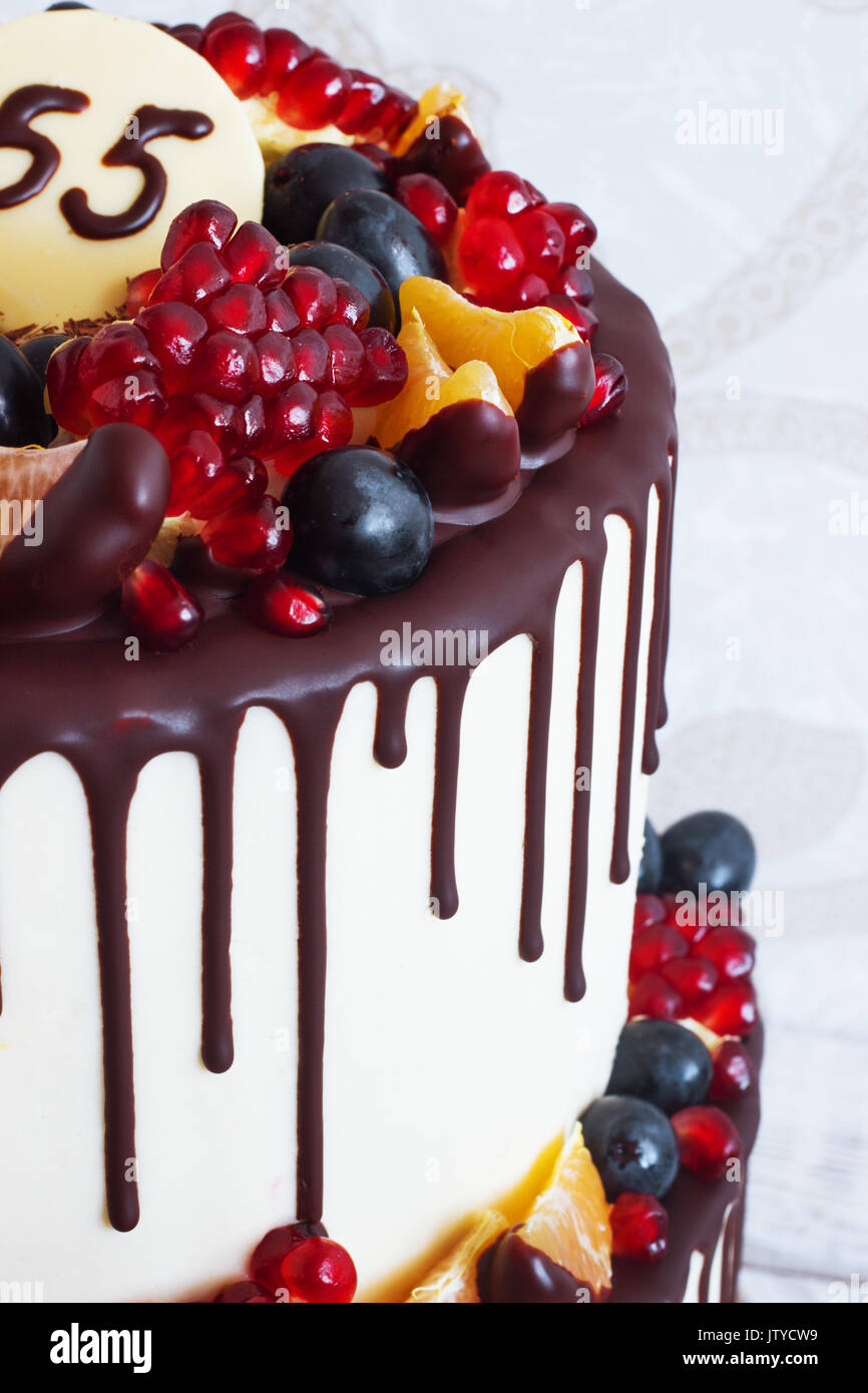 Deux niveaux de fête gâteau avec des fruits avec des traces de chocolat sur un fond clair Vue de dessus Banque D'Images