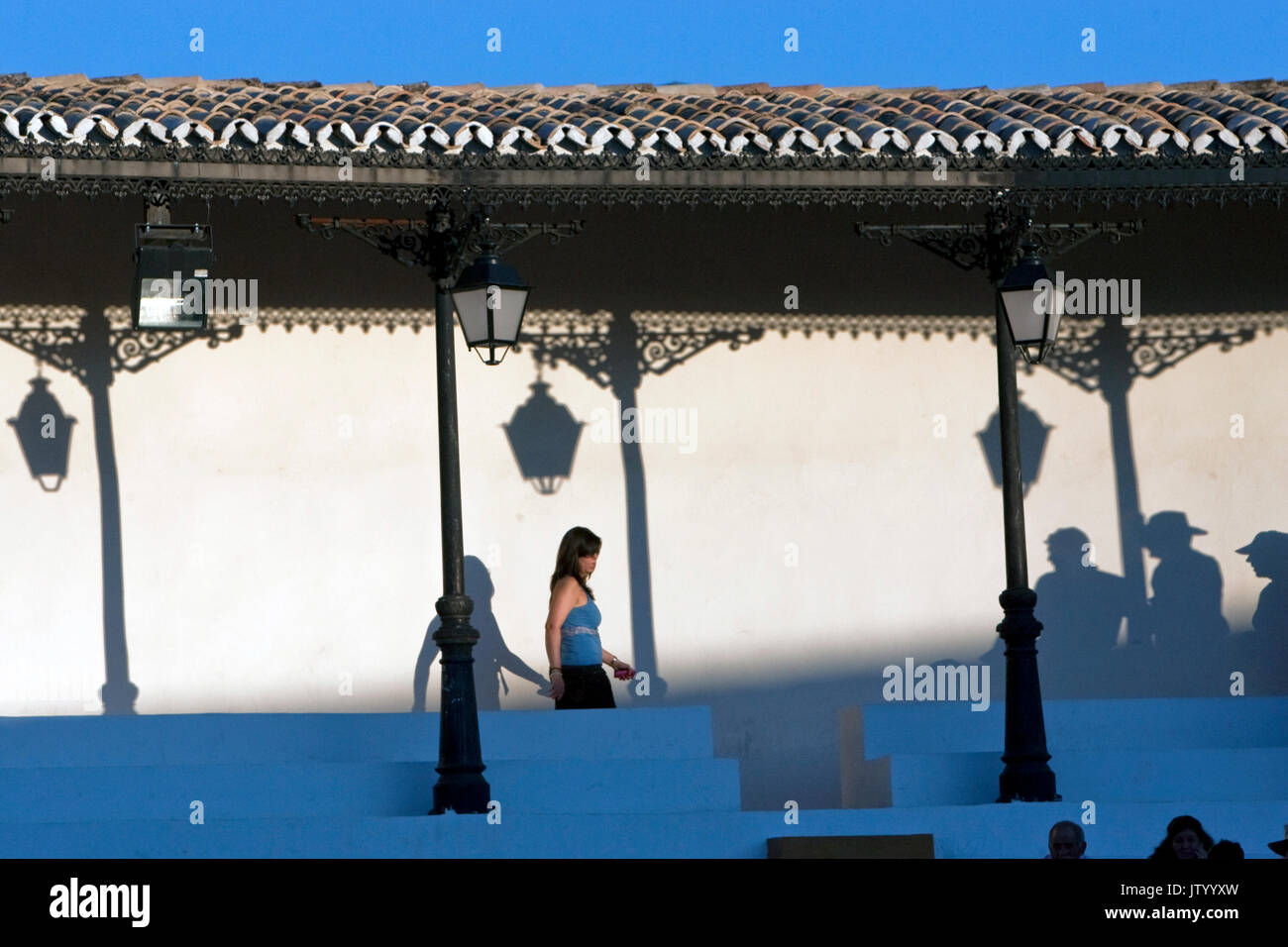 Silhouettes de plusieurs hommes dans une arène, une femme approches, Andalousie, Espagne Banque D'Images