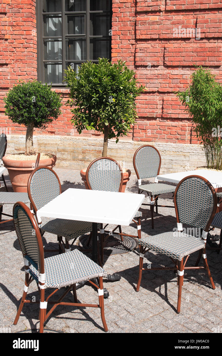 Café de la rue vide près de l'ancien bâtiment de brique sous la lumière du soleil Banque D'Images