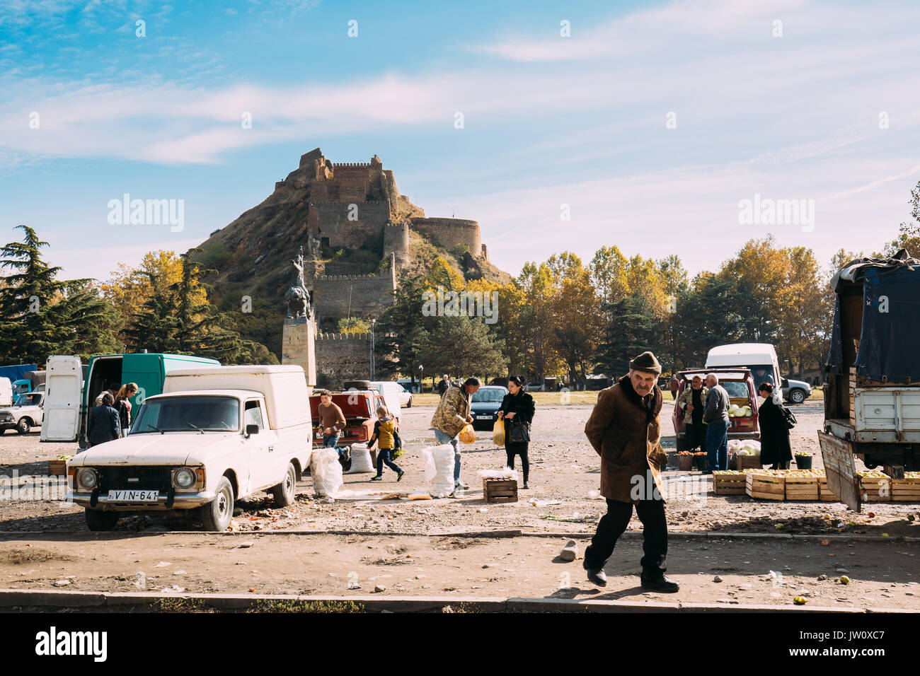 La région de Shida Kartli, Gori, en Géorgie. Vieux homme géorgienne autour de jetons avec des légumes sur le marché local dans la région ensoleillée Journée d'automne. Célèbre Forteresse Gori G Banque D'Images