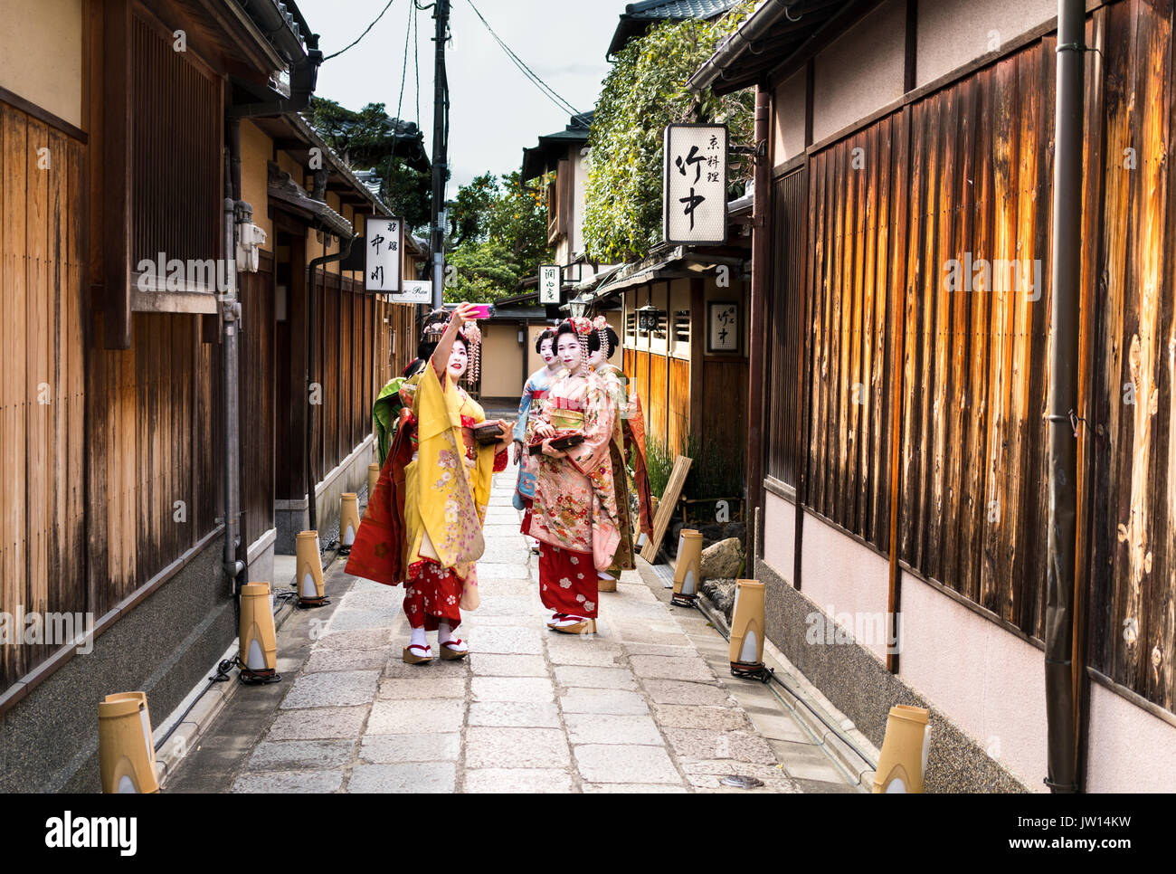 Groupe de quatre prendre une Geisha dans un selfies rue de Kyoto au Japon Banque D'Images