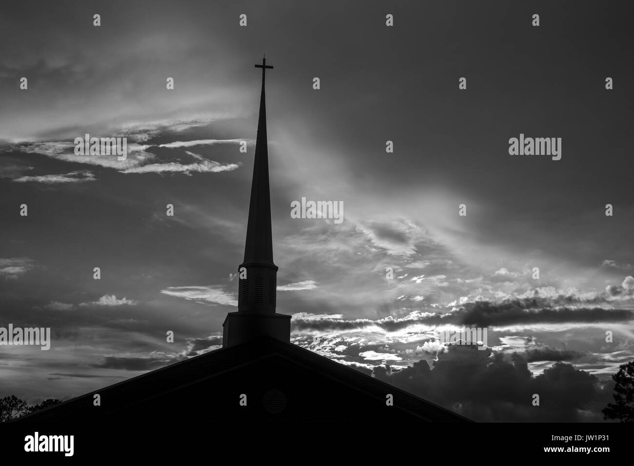 Coucher de soleil derrière un clocher de l'église après un après-midi pluvieux. Banque D'Images Coucher de soleil derrière un clocher de l'église après un après-midi pluvieux. Banque D'Images