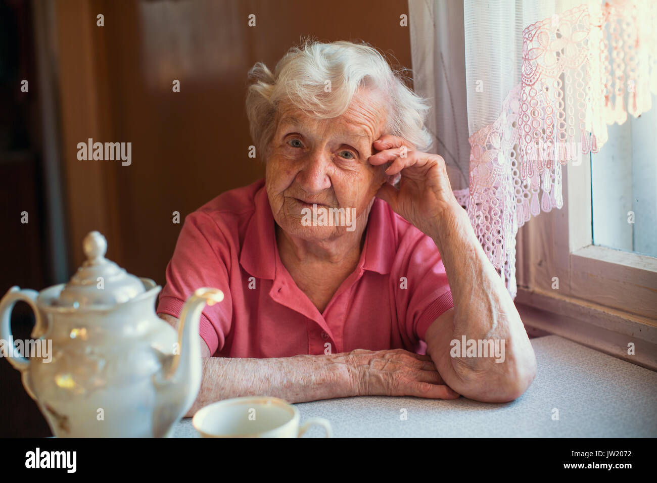 Portrait d'une femme âgée dans sa maison à la cuisine. Banque D'Images