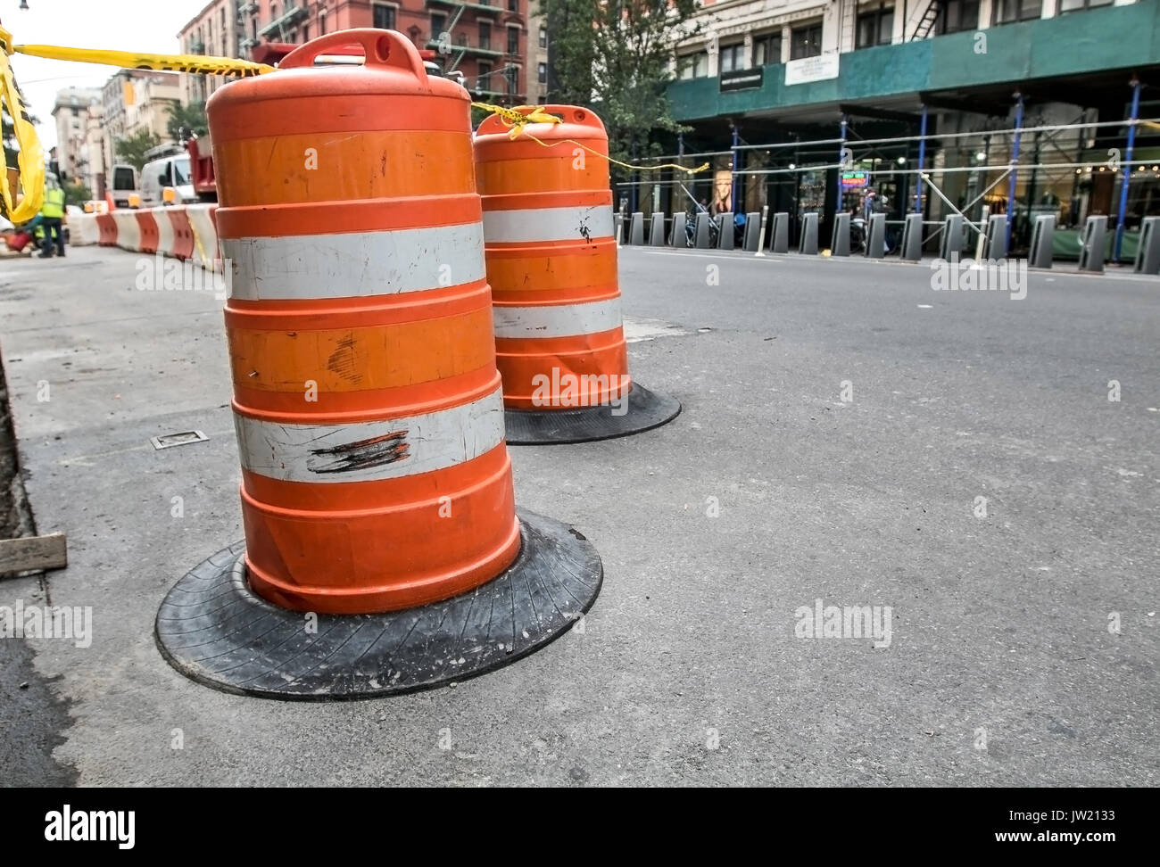 Le trafic d'une barricade de barils orange indique un site de travaux de construction de routes dans la région de Manhattan. Banque D'Images