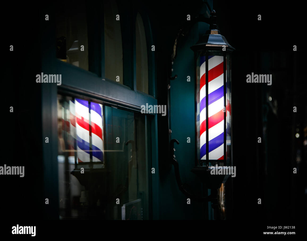 Pôle coiffure par l'entrée s'allume dans le noir. Banque D'Images
