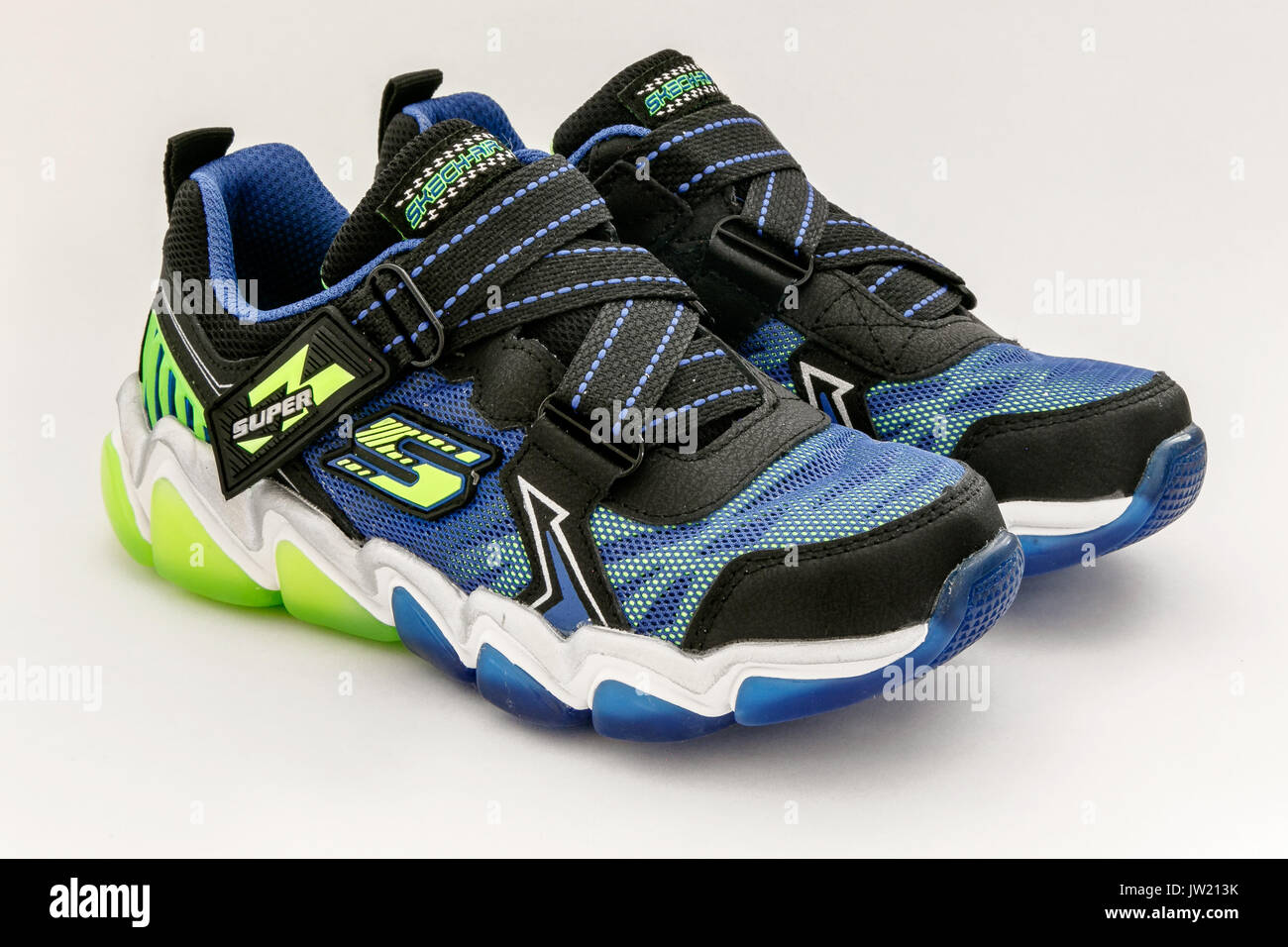 Une paire de baskets Sketchers du garçon contre l'arrière-plan blanc. Banque D'Images