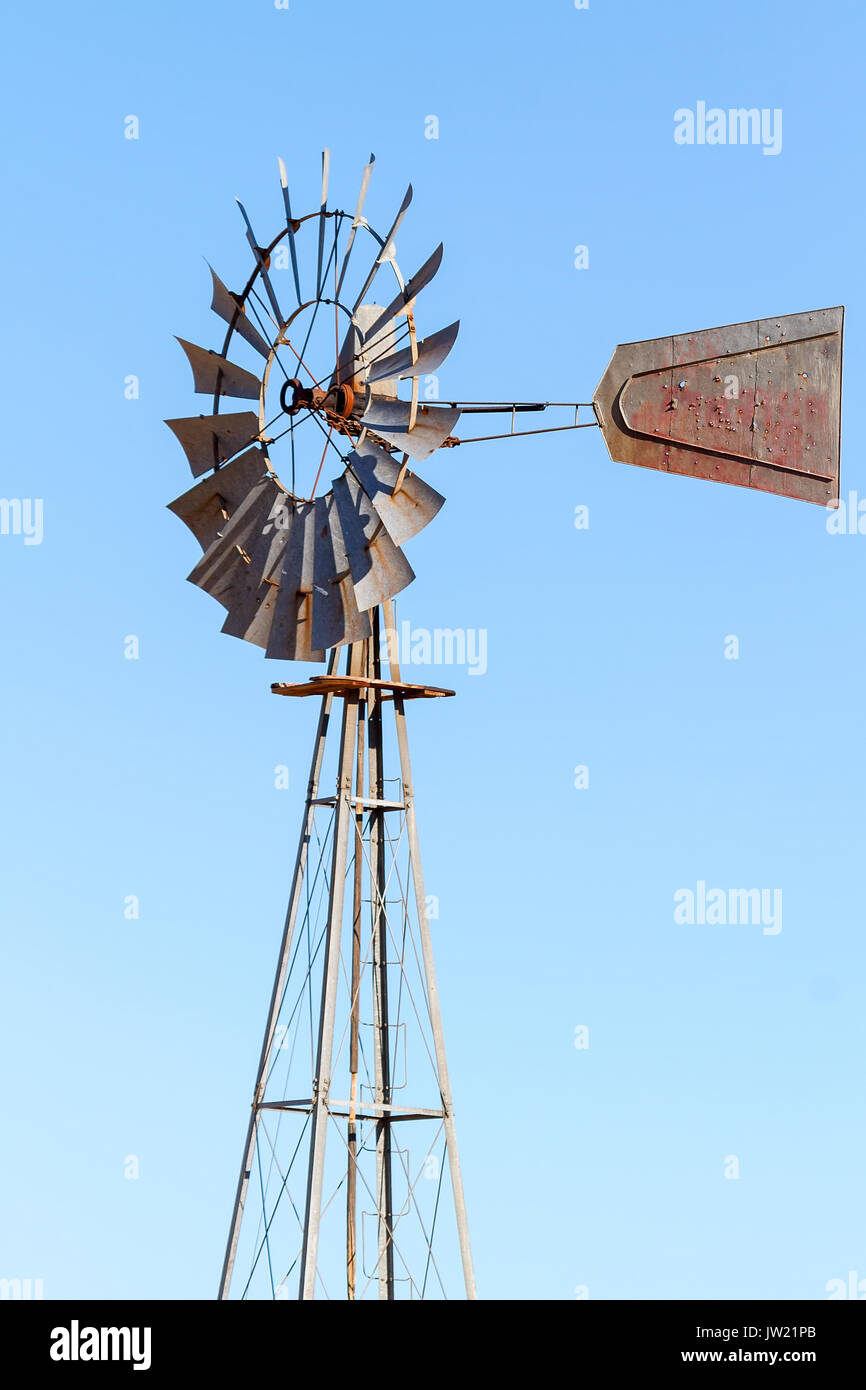 Le pompage de l'eau Moulin à champ de blé dans le centre de l'Oregon contre un fond de ciel bleu clair Banque D'Images