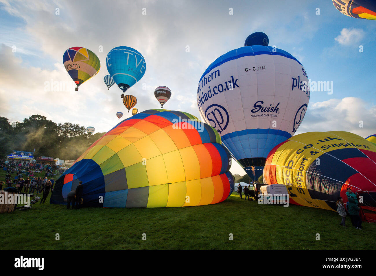 Montgolfières gonfler et soulever au cours de la première ascension de masse, où des ballons de tous les coins du monde se rassemblent à Ashton Cour, Bristol, à prendre part à la Bristol International Balloon Fiesta. Banque D'Images