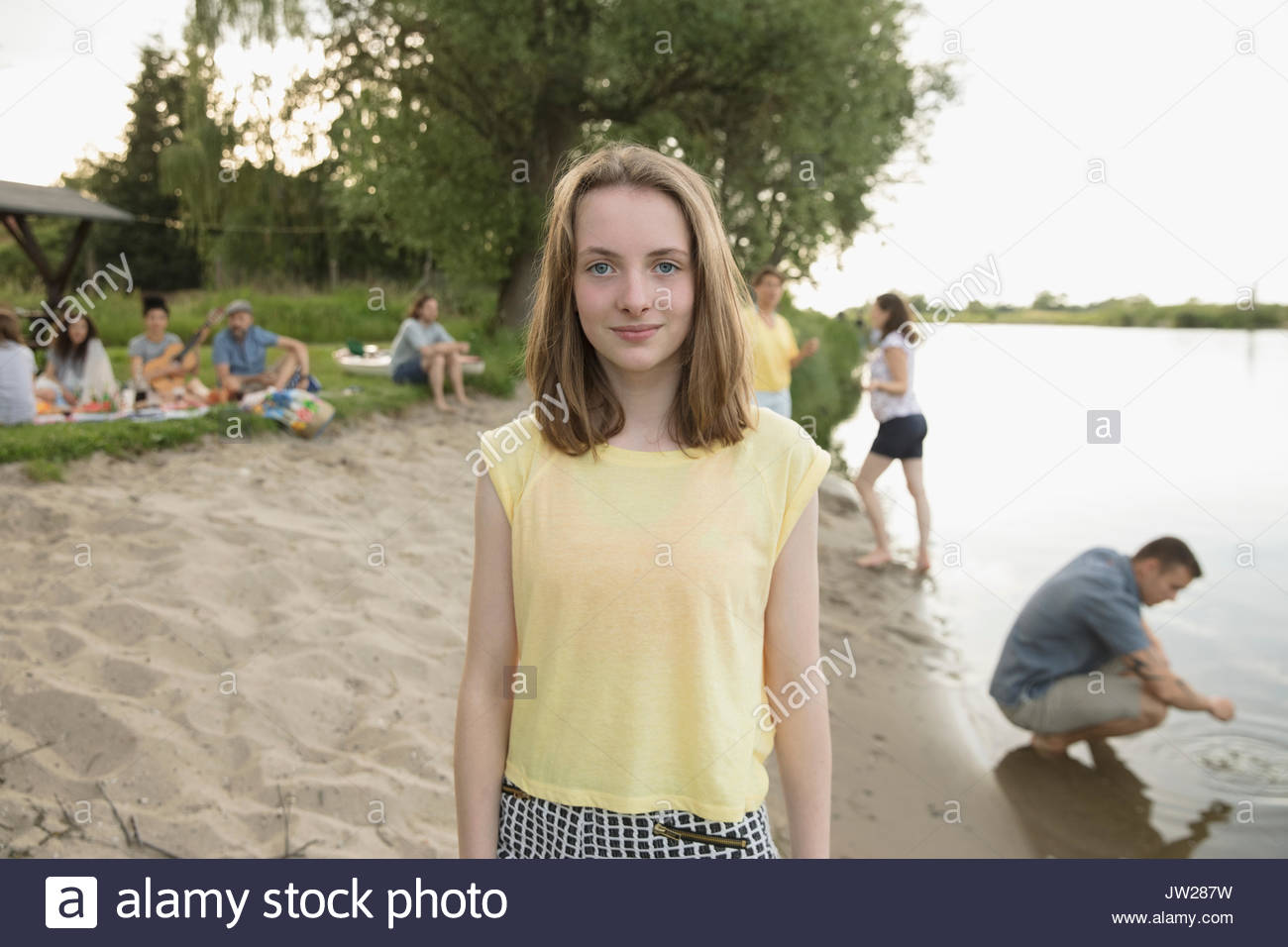 Portrait of smiling pré-adolescente sur plage au bord du lac d'été Banque D'Images