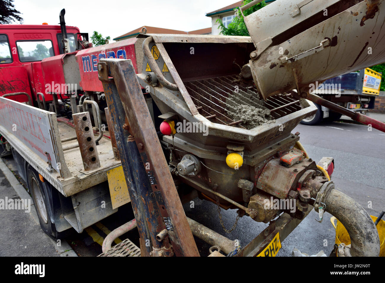 Close up de wagons-trémies sur chariot pompage de béton ont fait équipe avec un ready-mix bétonnière chariot pour une rénovation intérieure Banque D'Images
