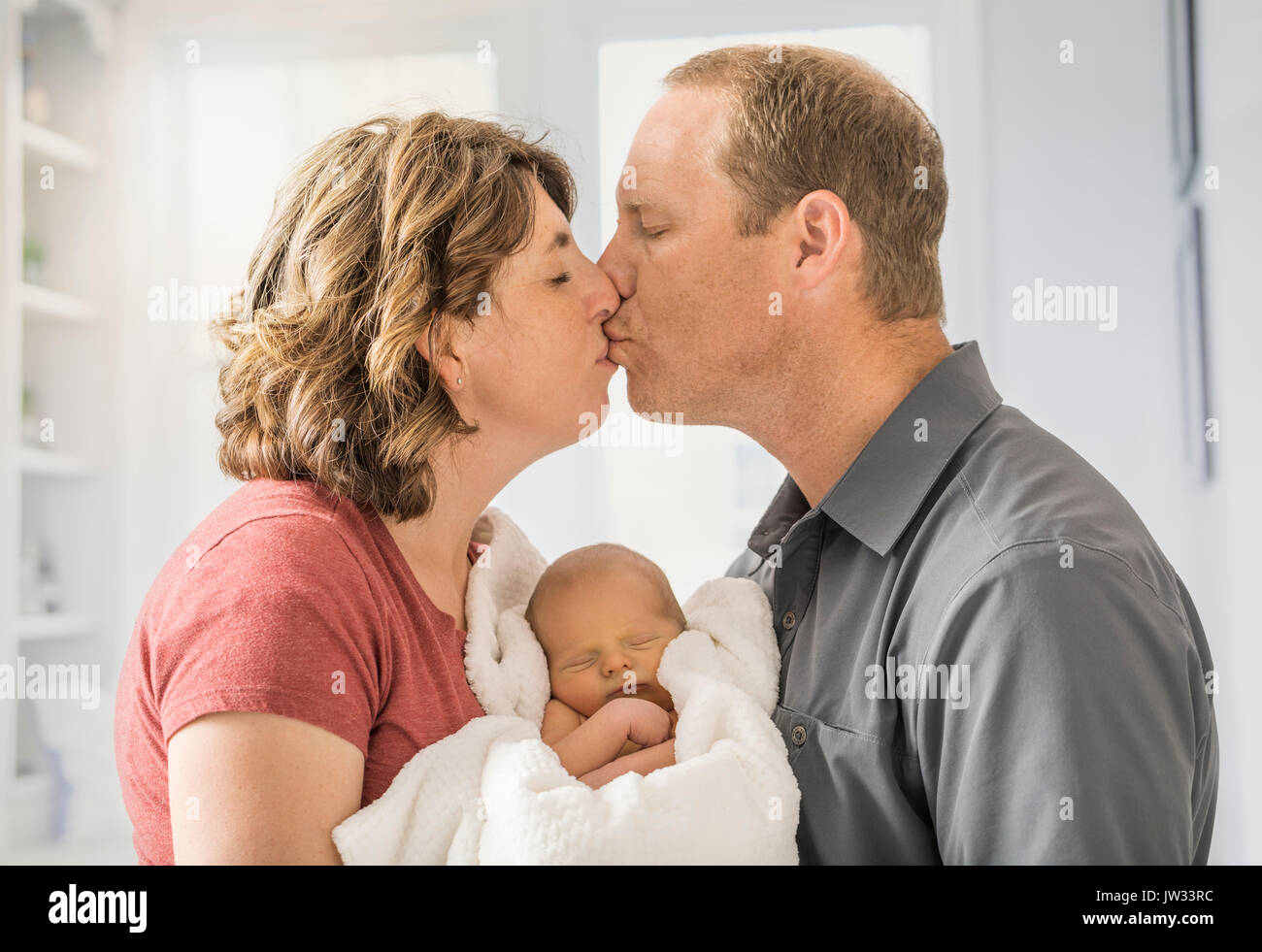 Les parents holding and baby son (0-1 mois) et à s'embrasser Banque D'Images