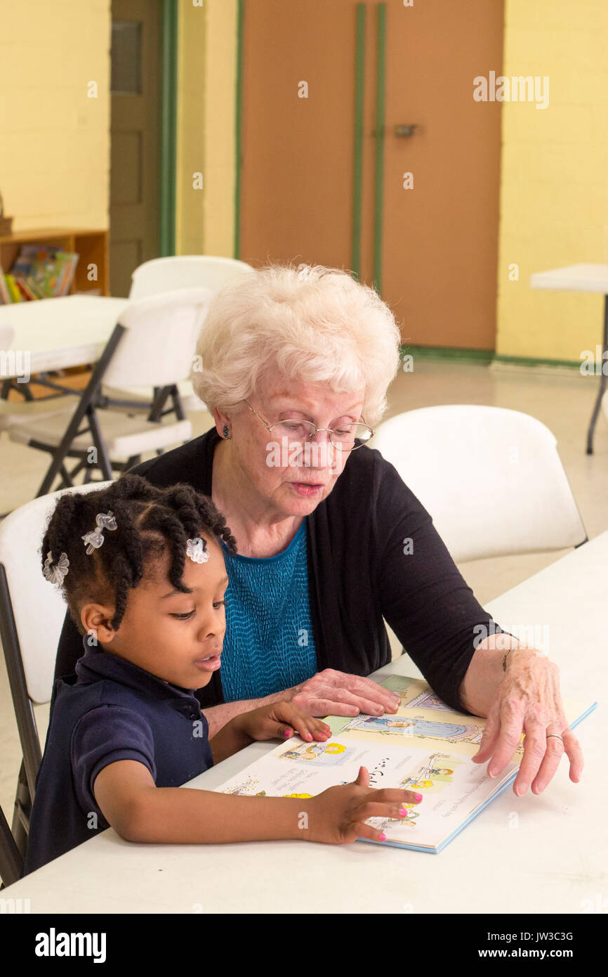 Spartanburg, Caroline du Sud - Mary Lou Miller, un bénévole, lit un livre à un enfant dans le S.O.A.R. au programme après l'école Centre de Bethléem, un co Banque D'Images