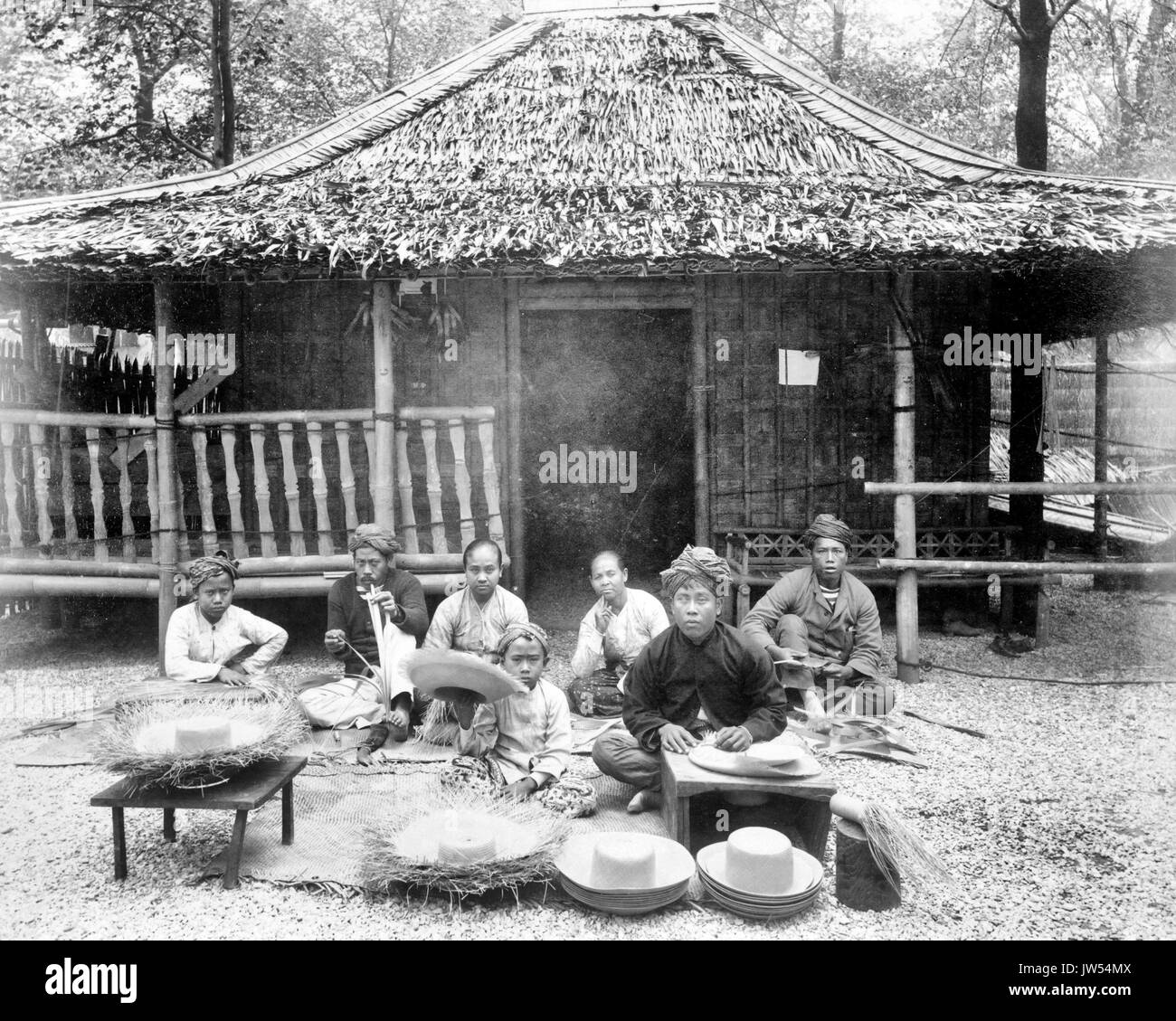 Chapeau de paille décideurs dans Village javanais javanais assis devant house, Exposition de Paris, 1889 Banque D'Images