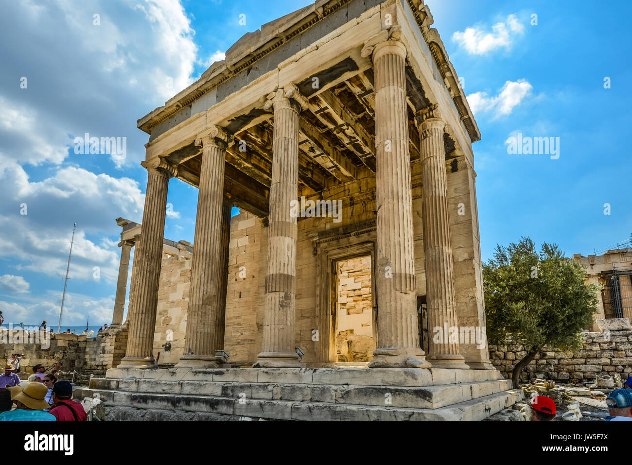 Ancient Erechtheion temple à l'Acropole à Athènes la Grèce sur une chaude journée d'été avec un ciel bleu et les touristes Banque D'Images