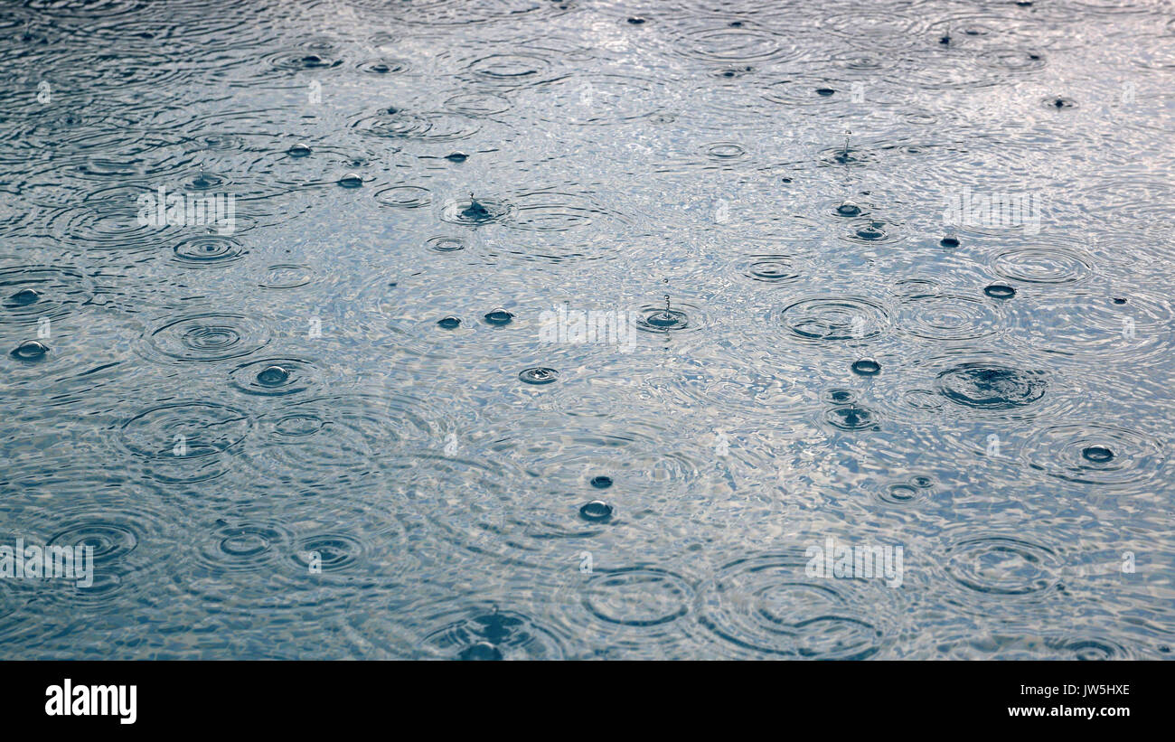 Gouttes de pluie tombant dans l'eau Résumé Contexte Banque D'Images